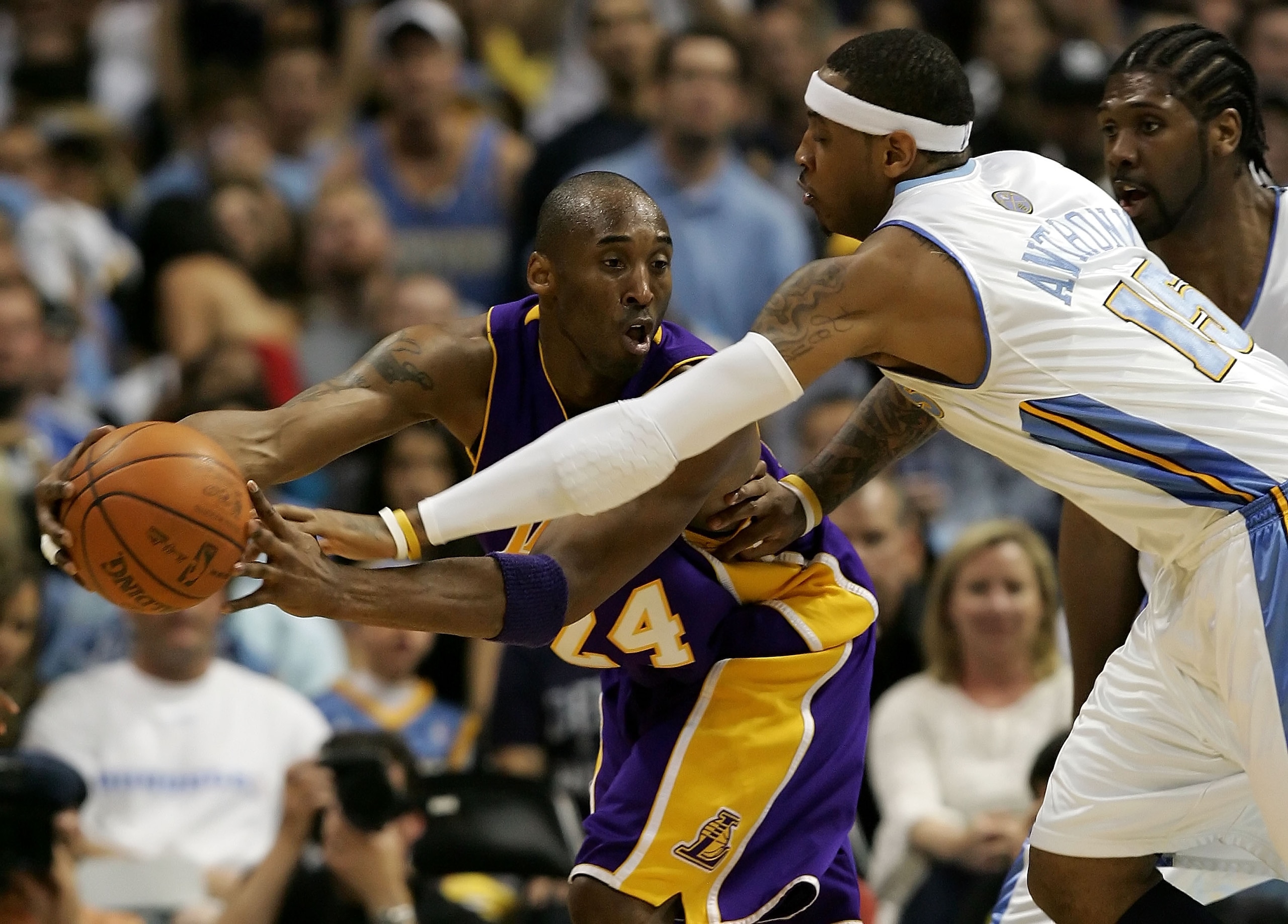 DENVER - MAY 23:  Kobe Bryant #24 of the Los Angeles Lakers looks to pass the ball around Carmelo Anthony #15 and Nene #31 of the Denver Nuggets in Game Three of the Western Conference Finals during the 2009 NBA Playoffs at Staples Center on May 23, 2009