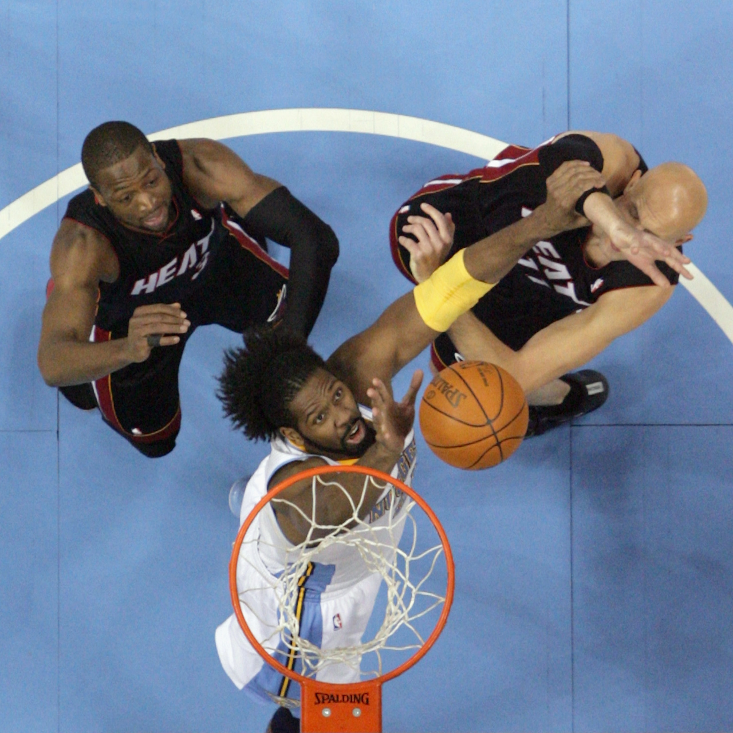 DENVER, CO - JANUARY 13:  Nene #31 of the Denver Nuggets battles for a rebound against Zydrunas Ilgaukas #11 and Dwayne Wade #3 of the Miami Heat at the Pepsi Center on January 13, 2011 in Denver, Colorado. The Nuggets defeated the Heat 130-102. NOTE TO U