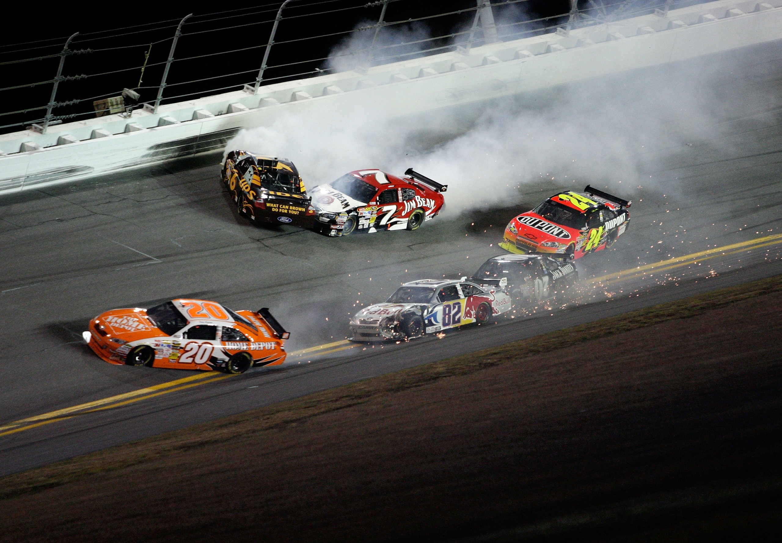 DAYTONA BEACH, FL - FEBRUARY 07:  David Ragan, driver of the #6 UPS Ford, and Robby Gordon, driver of the #7 Jim Beam Dodge, crash while Joey Logano, driver of the #20 Home Depot Toyota, and Scott Speed, driver of the #82 Red Bull Toyota, lose control of