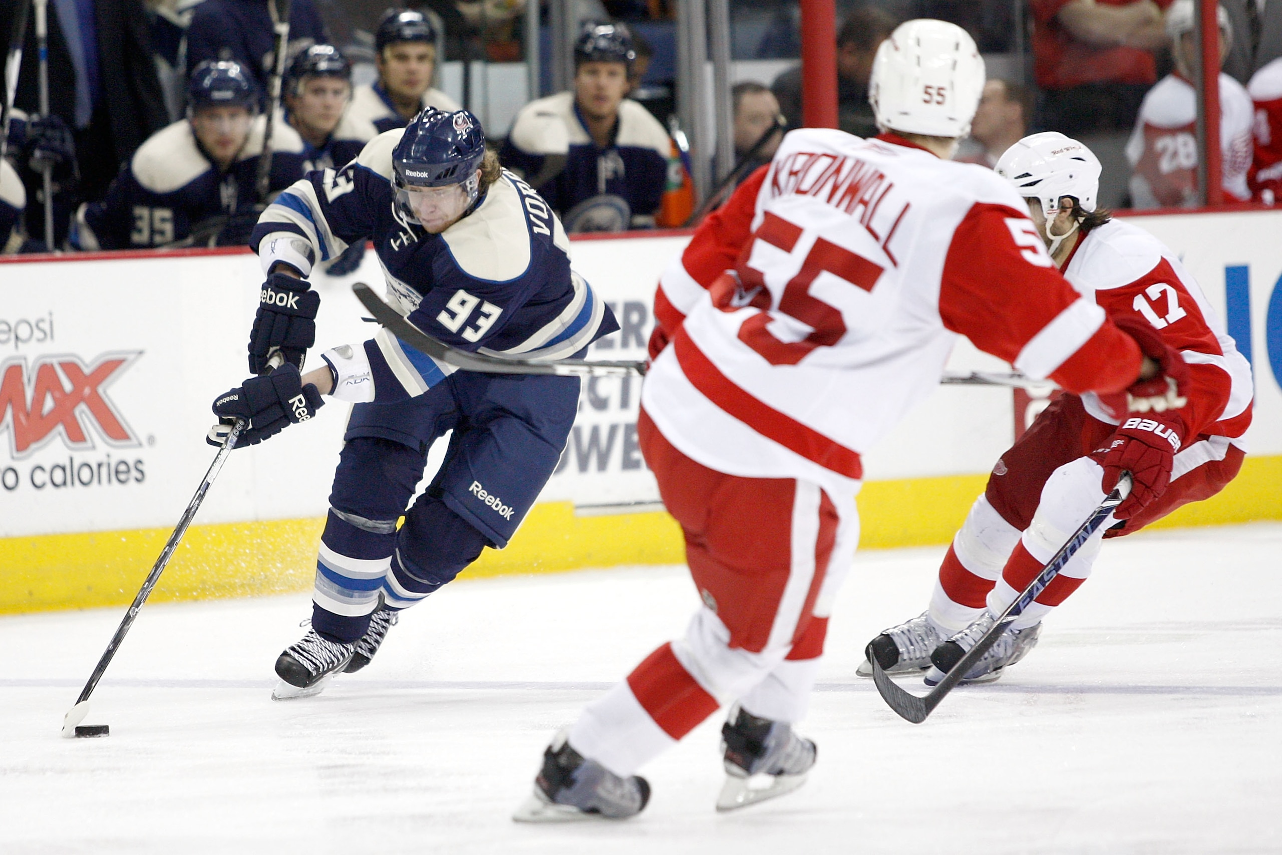 COLUMBUS, OH - JANUARY 14:  Jakub Voracek #93 of the Columbus Blue Jackets skates the puck up ice against Patrick Eaves #17 and Niklas Kronwall #55 of the Detroit Red Wings during the second period on January 14, 2011 at Nationwide Arena in Columbus, Ohio