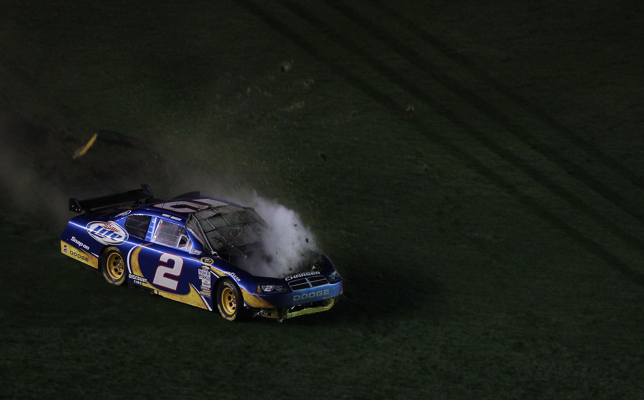DAYTONA BEACH, FL - FEBRUARY 06:  Kurt Busch, driver of the #2 Miller Lite Dodge drives over grass after losing control on the front straight during the Budweiser Shootout at Daytona International Speedway on February 6, 2010 in Daytona Beach, Florida.  (