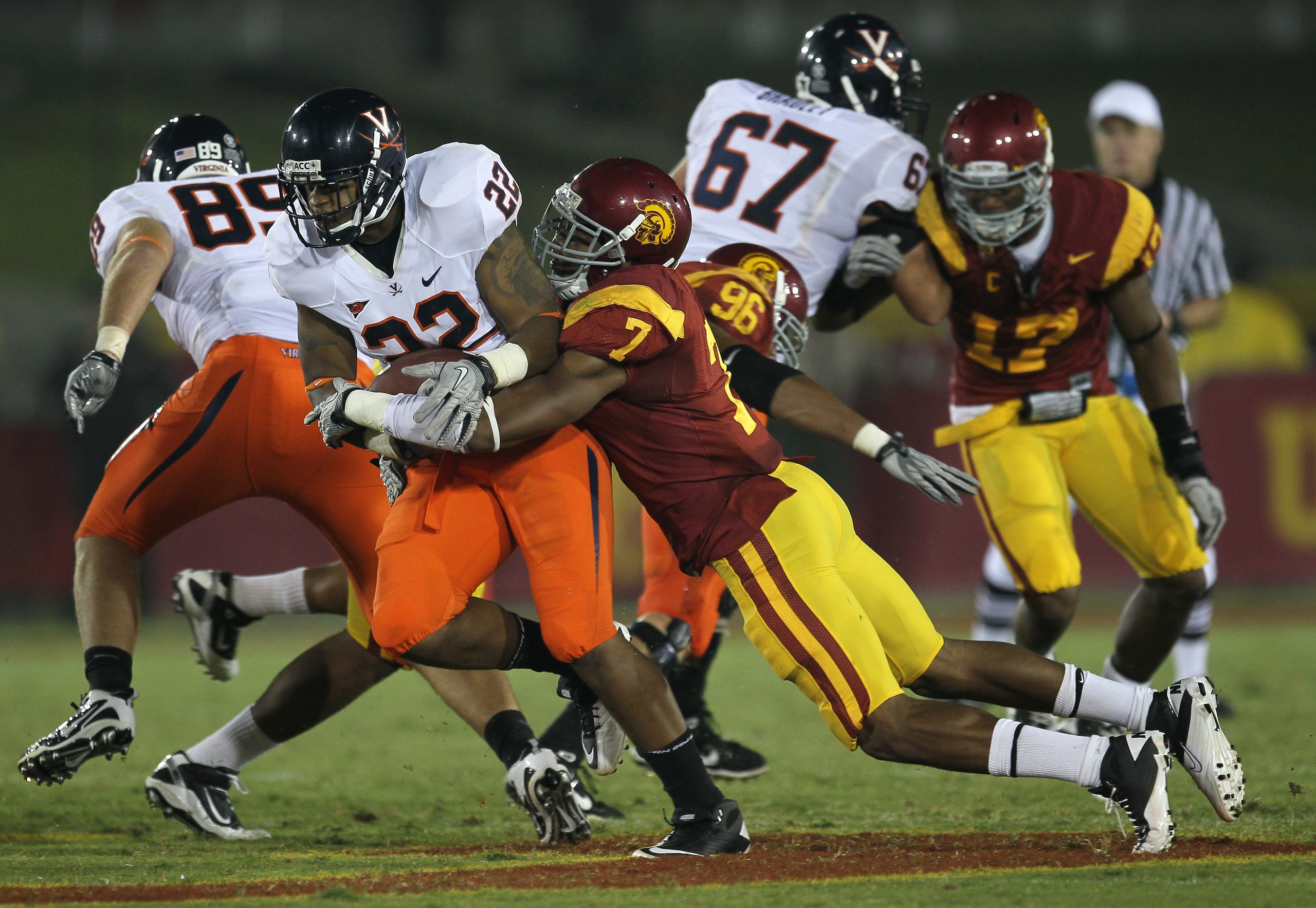 LOS ANGELES, CA - SEPTEMBER 11:  Safety T.J. McDonald #7 of the USC Trojans tackles running back Keith Payne #22 of the Virginia Cavaliers at Los Angeles Memorial Coliseum on September 11, 2010 in Los Angeles, California.  (Photo by Stephen Dunn/Getty Ima