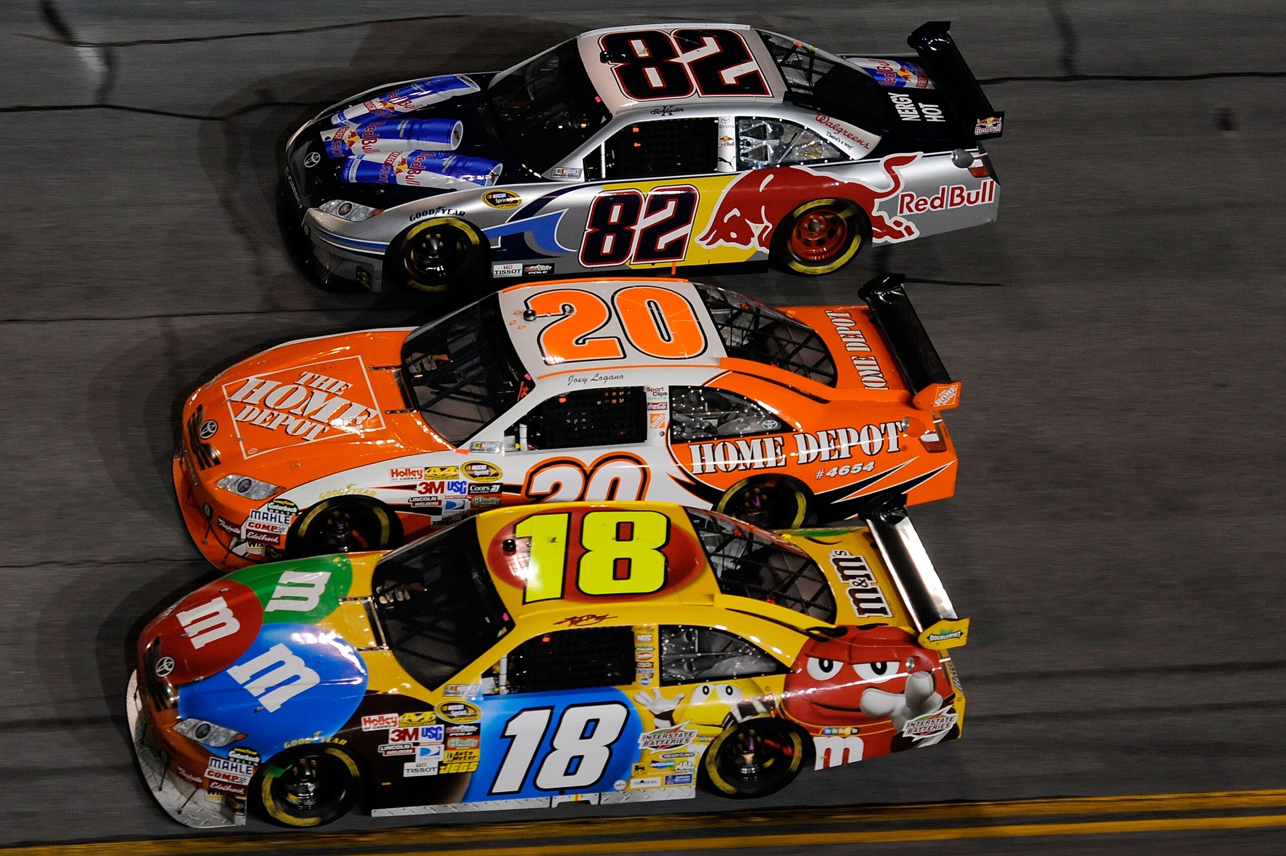 DAYTONA BEACH, FL - FEBRUARY 06:  Kyle Busch, driver of the #18 M&M's Toyota, races Joey Logano, driver of the #20 Home Depot Toyota, and Ken Schrader, driver of the #82 Red Bull Toyota, during the Budweiser Shootout at Daytona International Speedway on F
