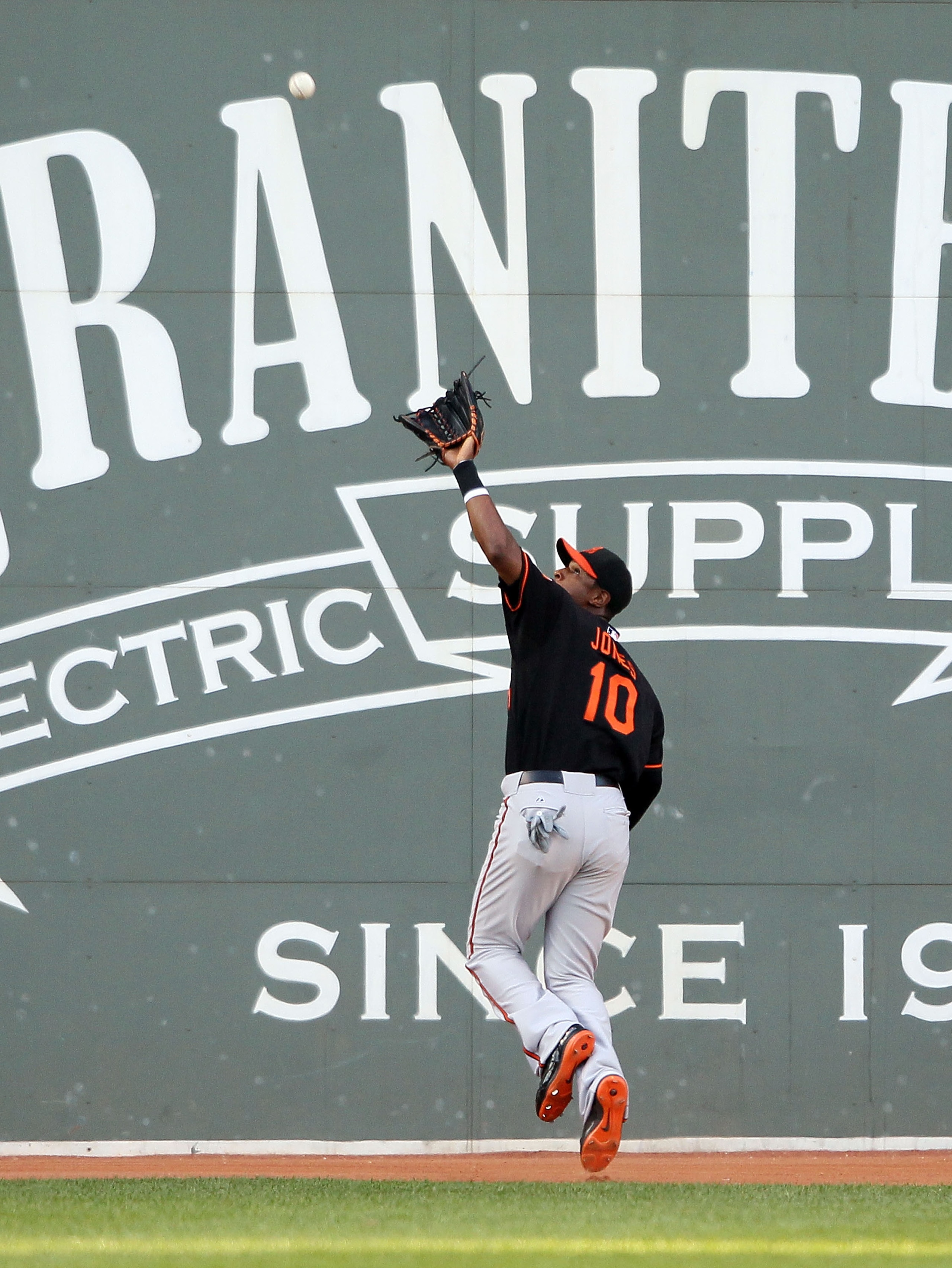 BOSTON - JULY 02:  Adam Jones #10 of the Baltimore Orioles makes the catch for the out on a hit by Eric Patterson of the Boston Red Sox on July 2, 2010 at Fenway Park in Boston, Massachusetts.  (Photo by Elsa/Getty Images)