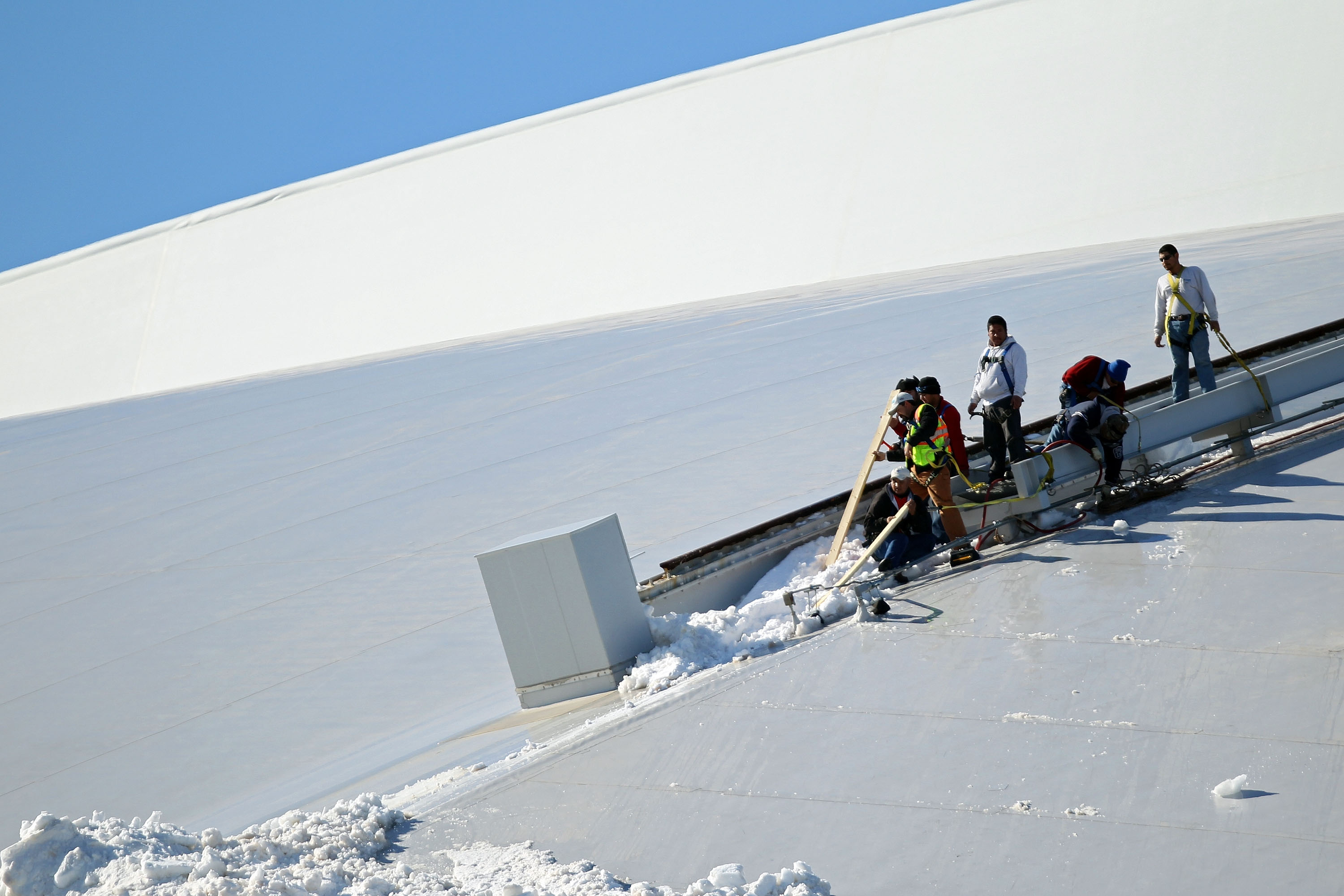 ARLINGTON, TX - FEBRUARY 05:  Workers clear ice and snow from atop Cowboys Stadium on February 5, 2011 in Arlington, Texas.  According to reports, at least six people were injured yesterday when large sheets of ice fell some 200 feet from the dome of the
