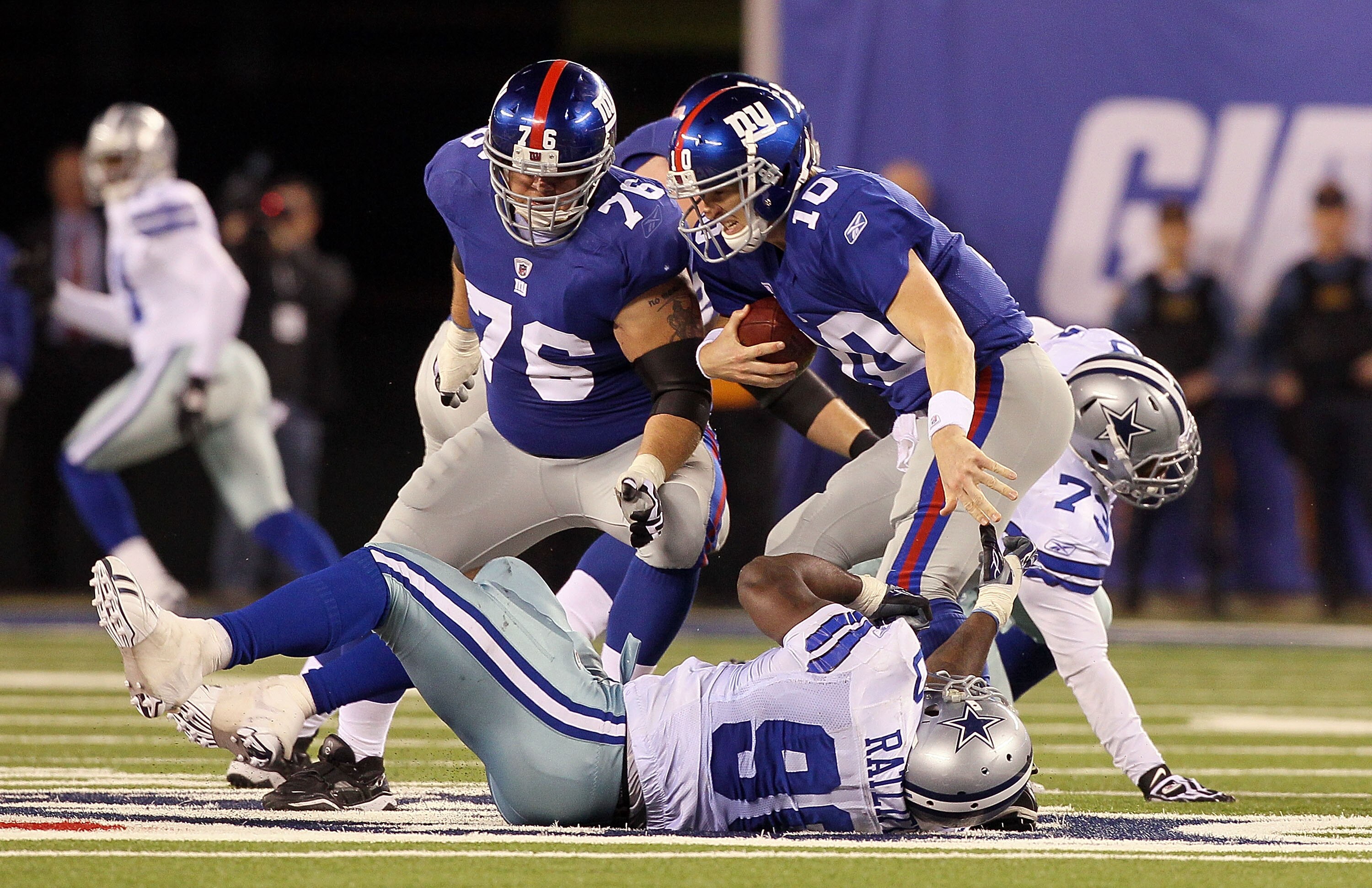 EAST RUTHERFORD, NJ - NOVEMBER 14:  Eli Manning #10 of the New York Giants scrambles to avoid a sack in the fourth quarter by Jay Ratliff #90 of the Dallas Cowboys on November 14, 2010 at the New Meadowlands Stadium in East Rutherford, New Jersey. The Cow