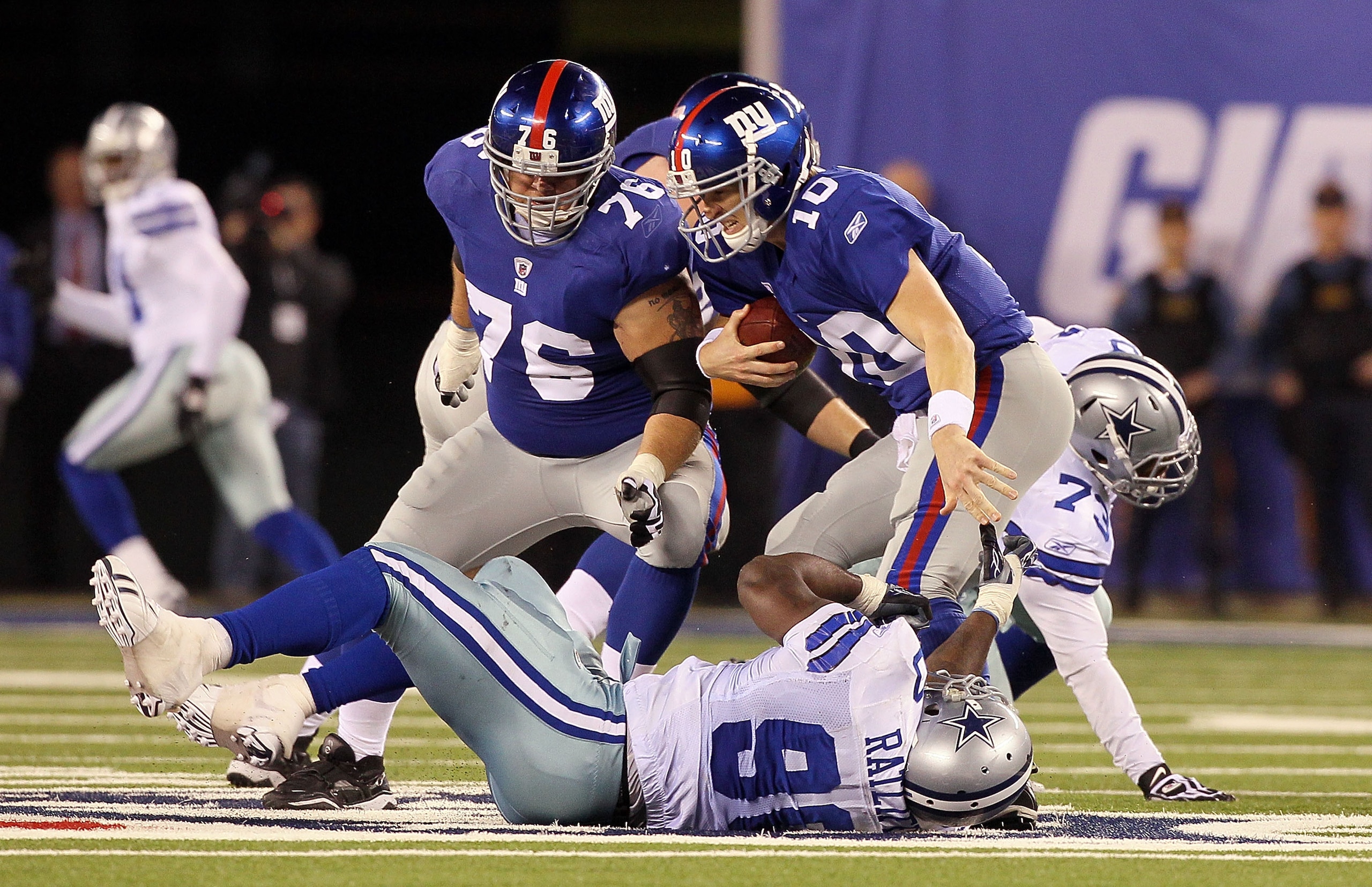 EAST RUTHERFORD, NJ - NOVEMBER 14:  Eli Manning #10 of the New York Giants scrambles to avoid a sack in the fourth quarter by Jay Ratliff #90 of the Dallas Cowboys on November 14, 2010 at the New Meadowlands Stadium in East Rutherford, New Jersey. The Cow