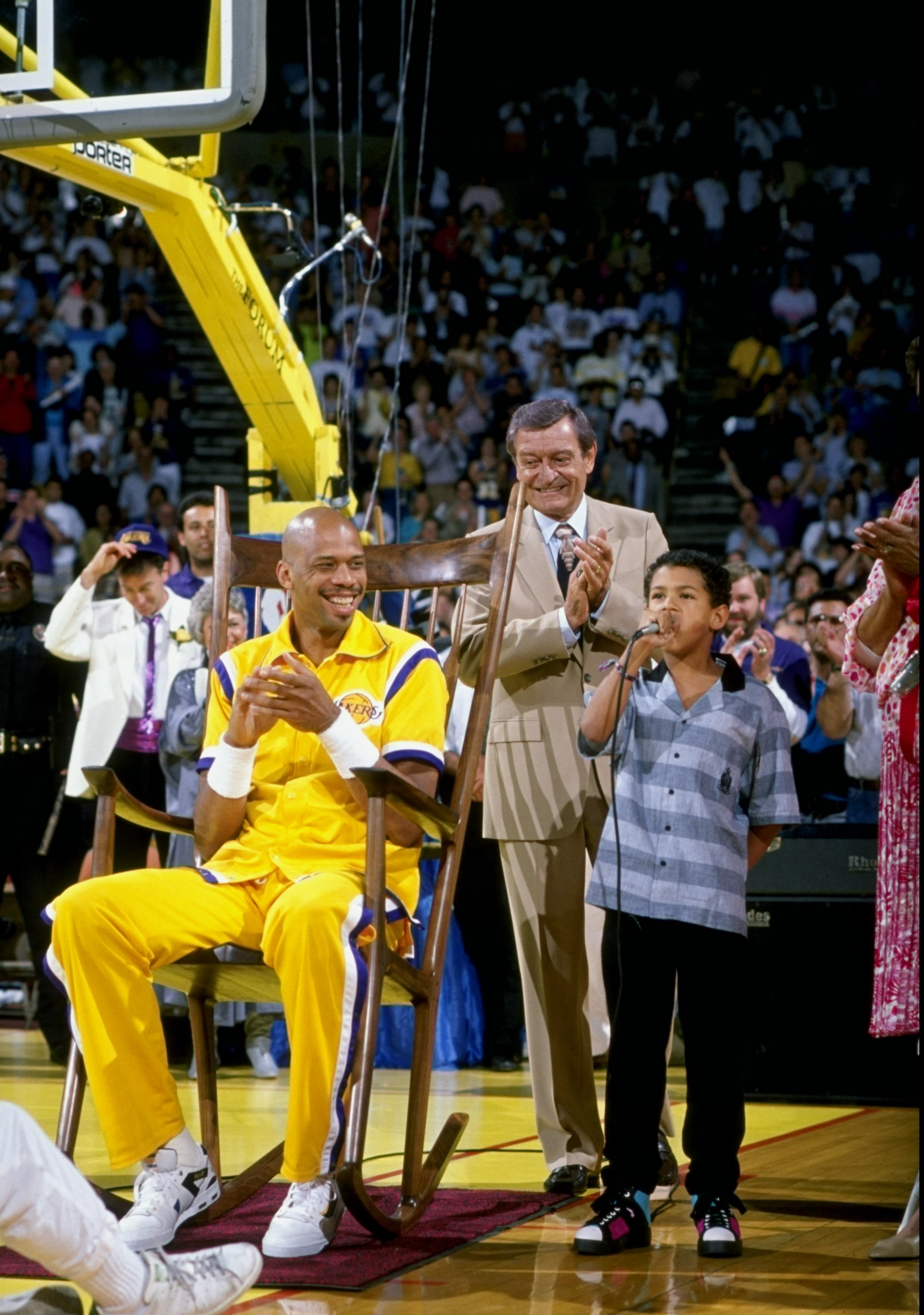 INGLEWOOD, CA - 1990:  Announcer Chick Hearn (center) and Kareem Abdul-Jabbar #33 of the Los Angeles Lakers attend a ceremony for the retirement of Jabbar's jersey number at the Great Western Forum in Inglewood, California.  (Photo by Stephen Dunn/Getty I