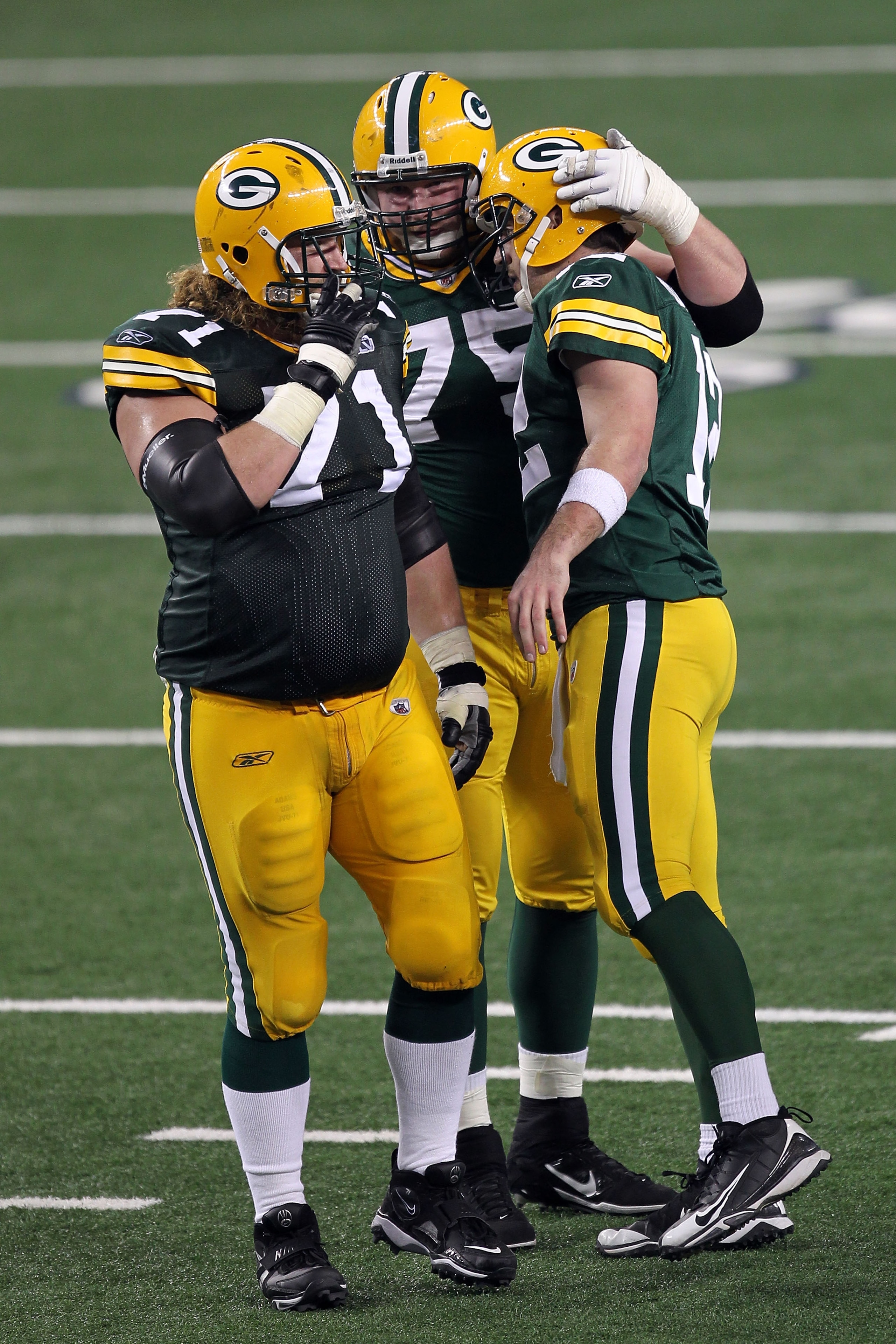 ARLINGTON, TX - FEBRUARY 06: Josh Sitton #71, Bryan Bulaga #75 and Aaron Rodgers #12 of the Green Bay Packers celebrate after a 8 yard touchdown pass against the Pittsburgh Steelers during Super Bowl XLV at Cowboys Stadium on February 6, 2011 in Arlington