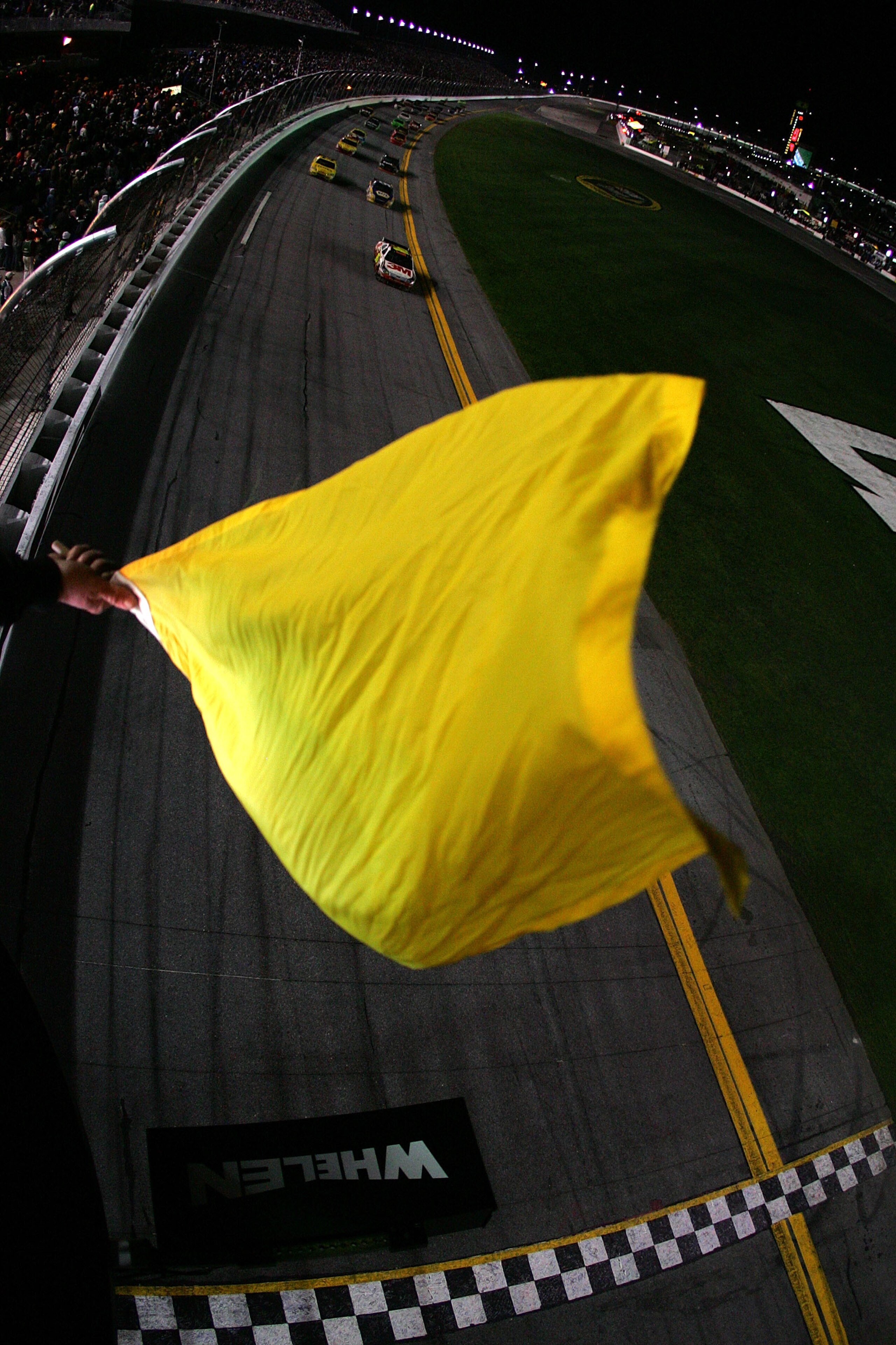 DAYTONA BEACH, FL - FEBRUARY 14:  Officials wave a yellow caution flag late in the NASCAR Sprint Cup Series Daytona 500 at Daytona International Speedway on February 14, 2010 in Daytona Beach, Florida.  (Photo by Todd Warshaw/Getty Images for NASCAR)