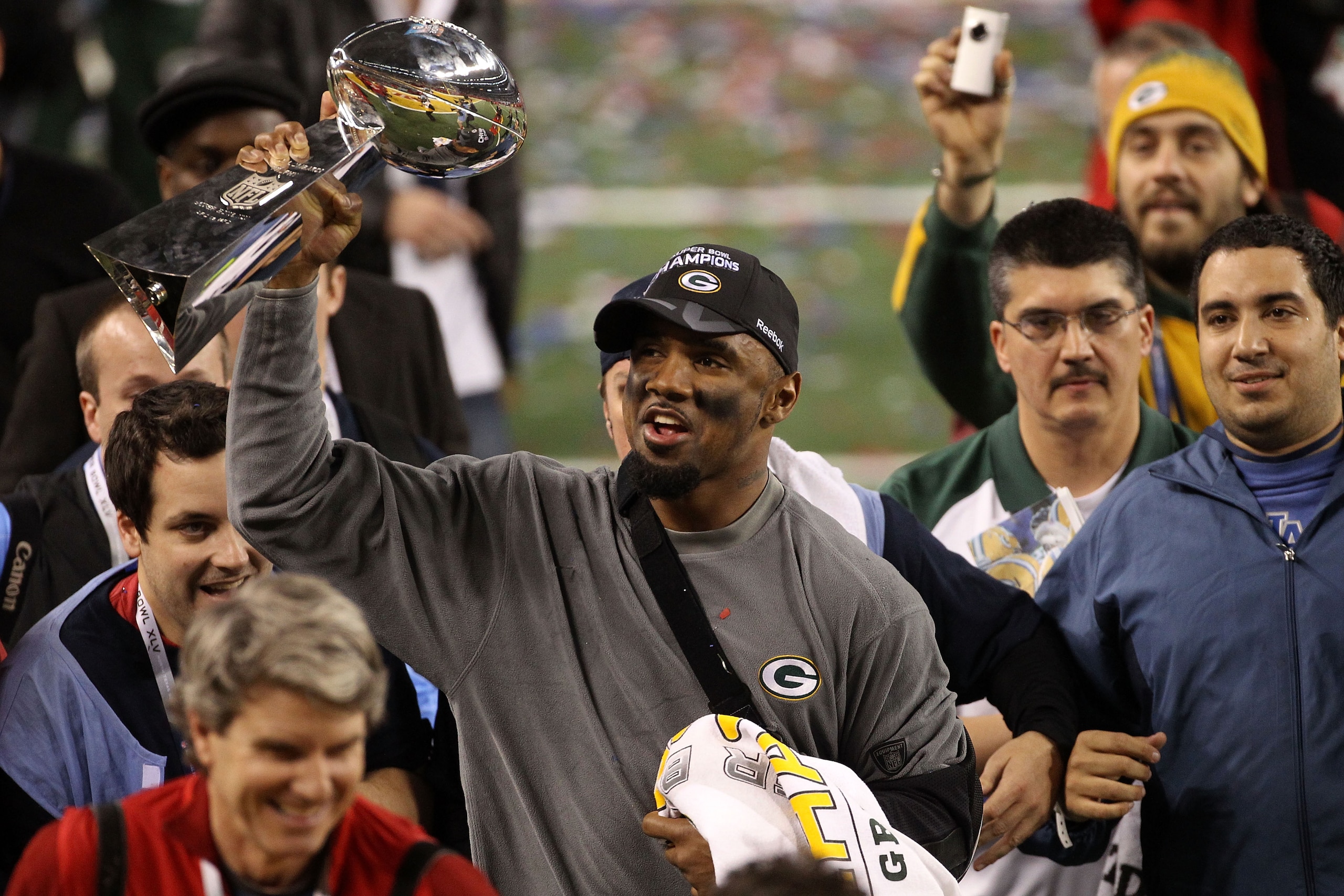 ARLINGTON, TX - FEBRUARY 06:  Charles Woodson #21 of the Green Bay Packers holds up the Lombardi Trophy after winning Super Bowl XLV 31-25 against the Pittsburgh Steelers at Cowboys Stadium on February 6, 2011 in Arlington, Texas. Woodson left the game wi