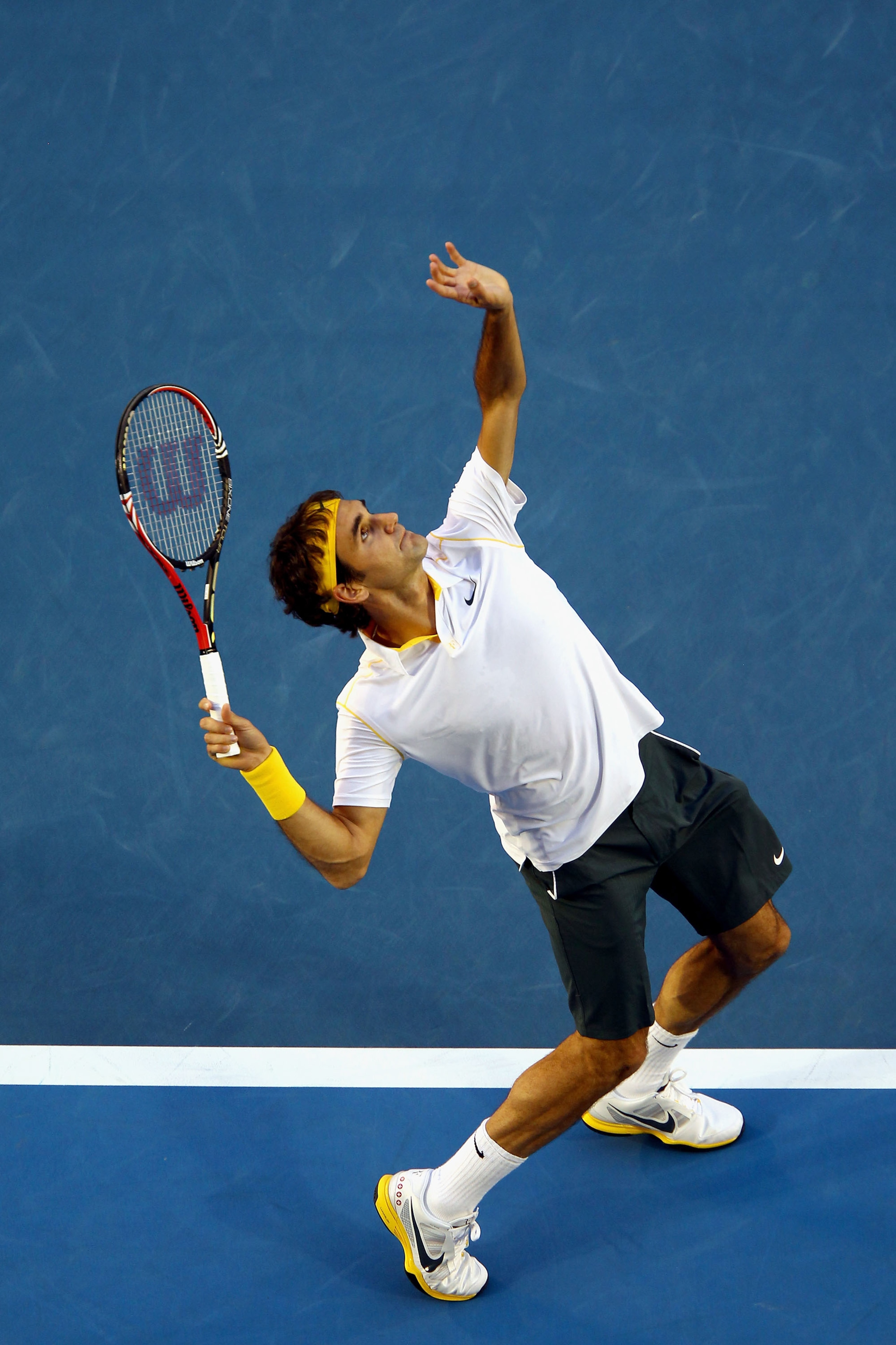 MELBOURNE, AUSTRALIA - JANUARY 27:  Roger Federer of Switzerland serves in his semifinal match against Novak Djokovic of Serbia during day eleven of the 2011 Australian Open at Melbourne Park on January 27, 2011 in Melbourne, Australia.  (Photo by Clive B