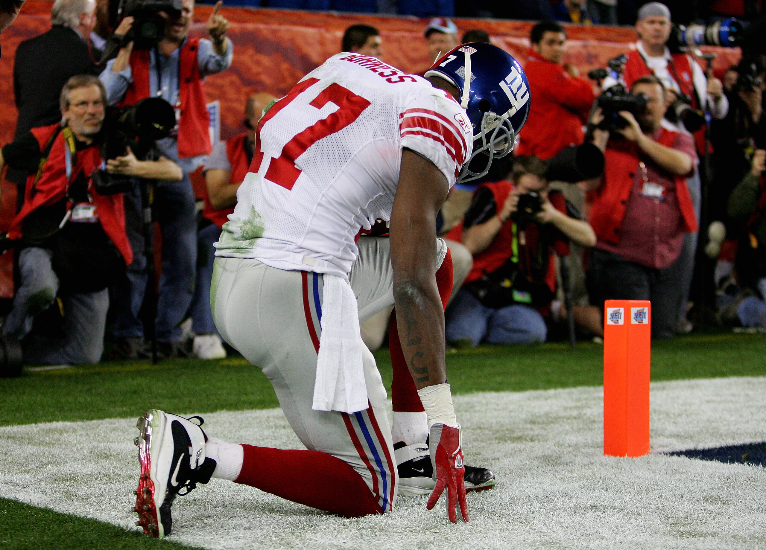 GLENDALE, AZ - FEBRUARY 03:  Wide receiver Plaxico Burress #17 of the New York Giants kneels after catching a 13-yard touchdown pass in the fourth quarter against the New England Patriots during Super Bowl XLII on February 3, 2008 at the University of Pho