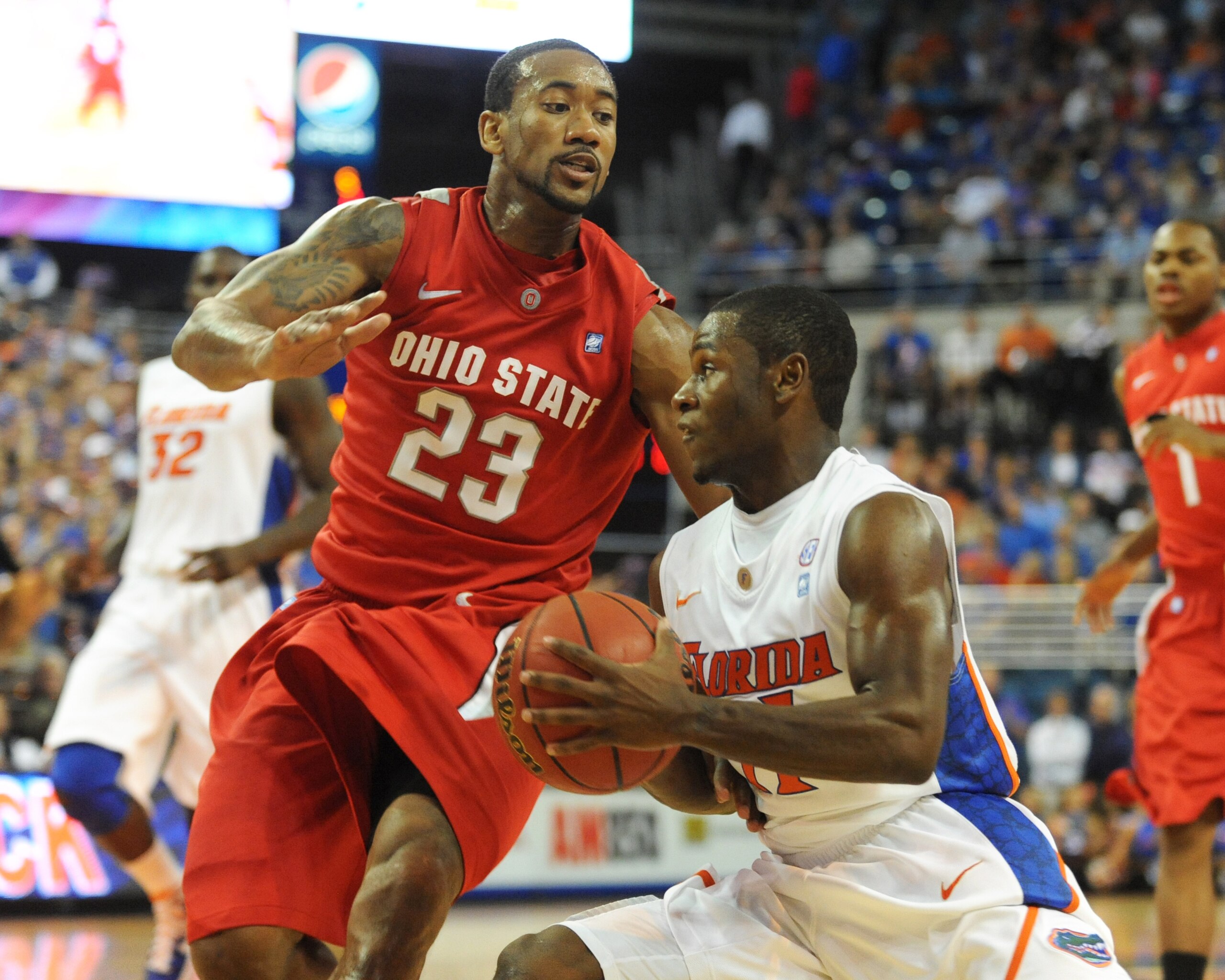 GAINESVILLE, FL - NOVEMBER 16: Guard Erving Walker #11 of the Florida Gators drives into guard David Lighty #23 of the Ohio State Buckeyes November 16, 2010 at the Stephen C. O'Connell Center in Gainesville, Florida.  (Photo by Al Messerschmidt/Getty Imag