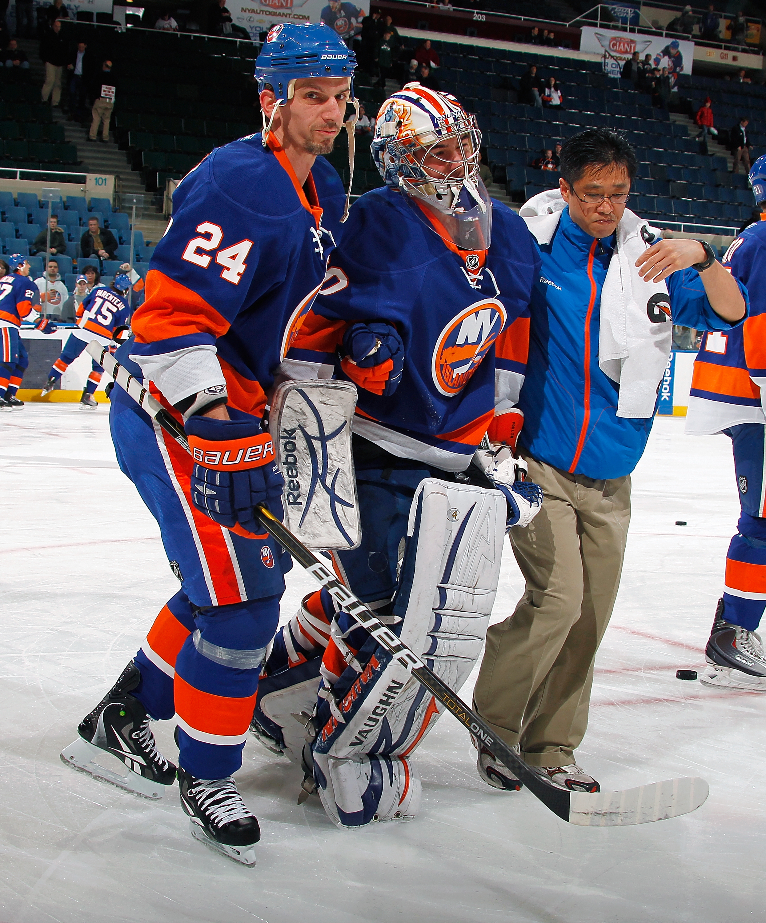 UNIONDALE, NY - FEBRUARY 08:  Kevin Poulin #60 of the New York Islanders is helped off the ice by Radek Martinek #24 and Assistant Athletic Trainer Nates Goto after being injured during warmups on February 8, 2011 at Nassau Colsium in Uniondale, New York.