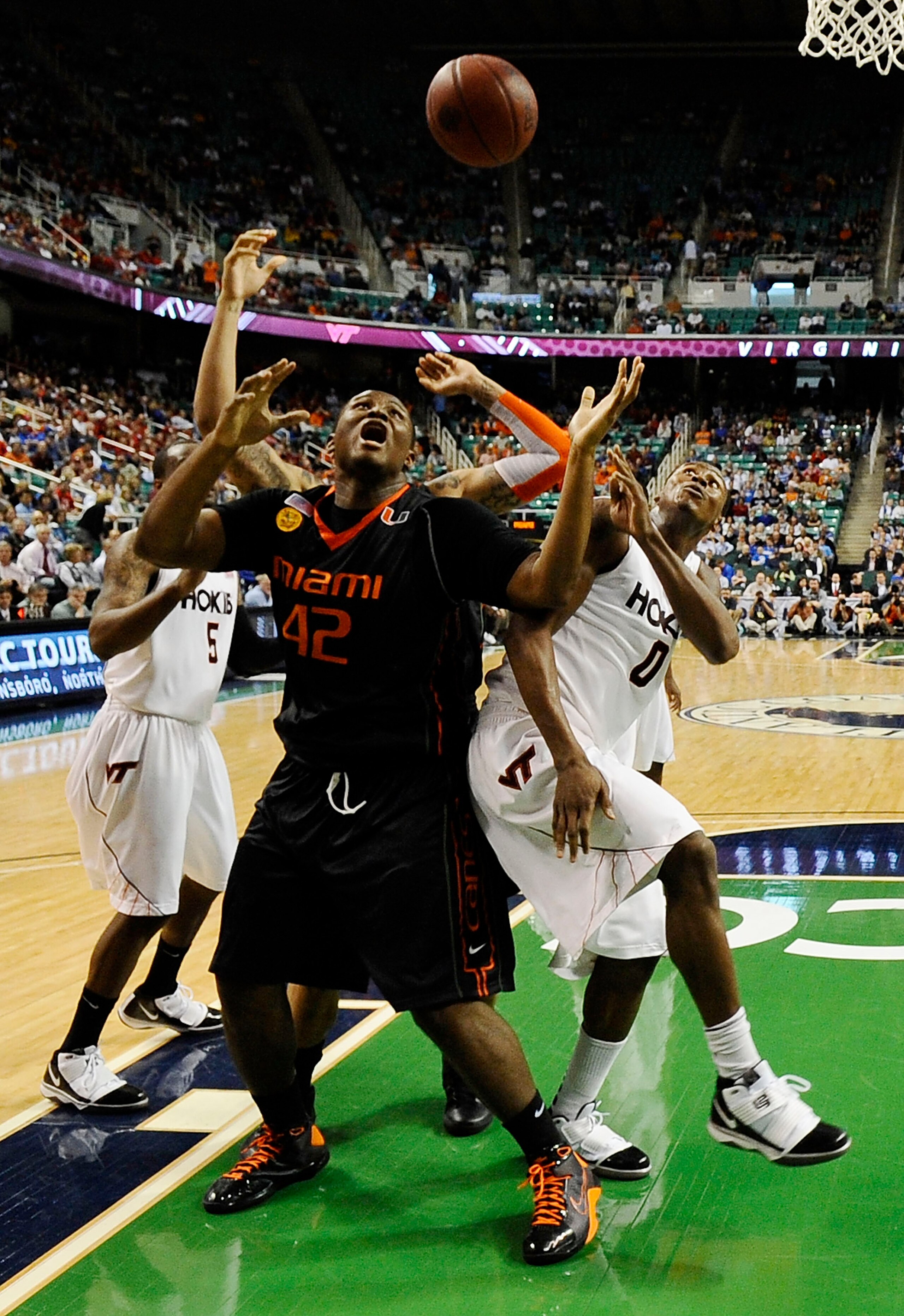 GREENSBORO, NC - MARCH 12:  Jeff Allen #00 of the Virginia Tech Hokies fights for a loose ball with Reggie Johnson #42 of the University of Miami Hurricanes in their quarterfinal game in the 2010 ACC Men's Basketball Tournament at the Greensboro Coliseum