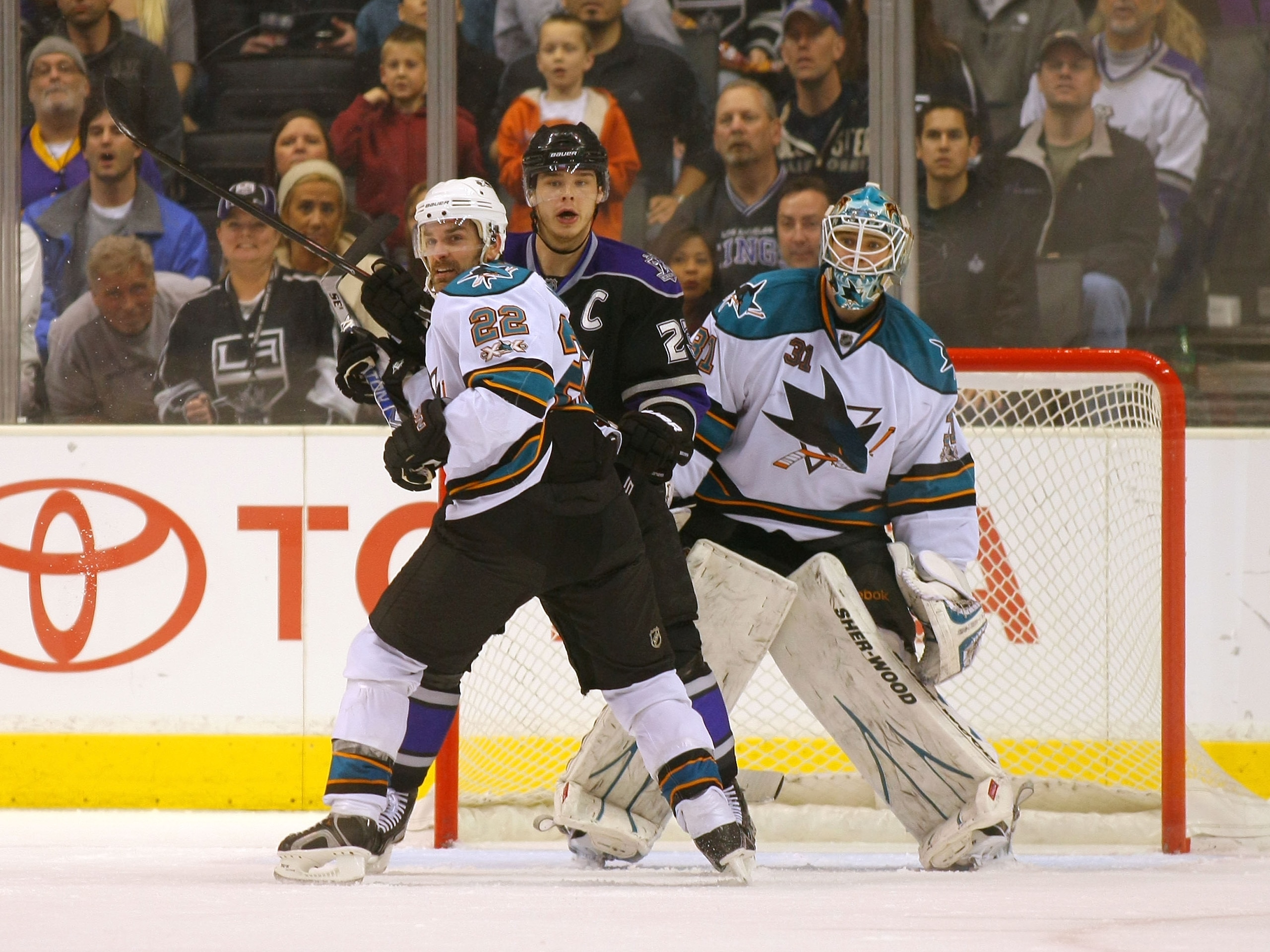 LOS ANGELES, CA - JANUARY 26:  Dan Boyle #22 of the San Jose Sharks defends Dustin Brown #23 of the Los Angeles Kings in the Sharks crease area in front of goaltender Antti Niemi #31 of the San Jose Sharks during their NHL game at Staples Center on Januar