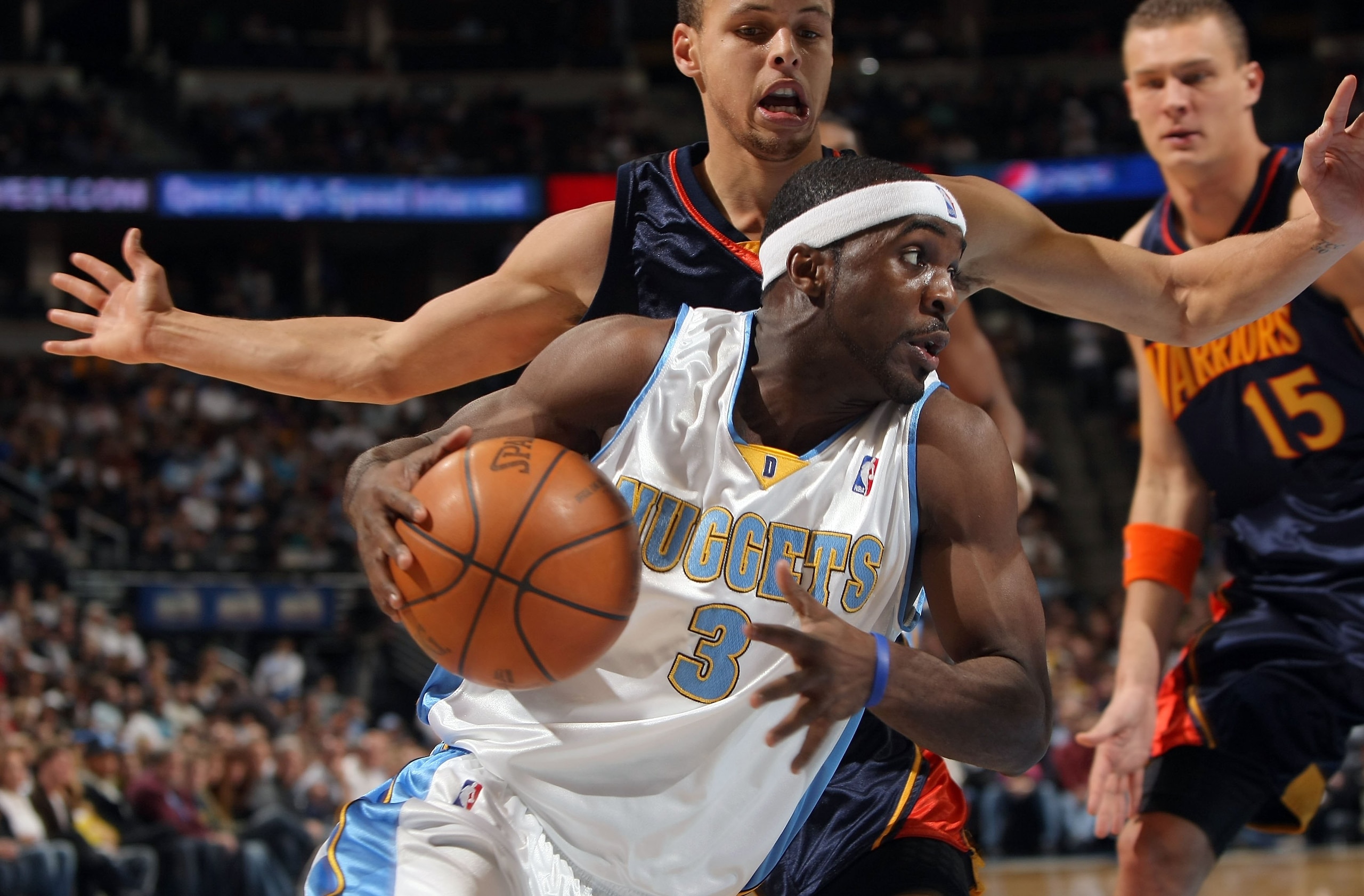 DENVER - JANUARY 05:  Ty Lawson #3 of the Denver Nuggets drives the ball past Stephen Curry #30 and Andris Biedrins #15 of the Golden State Warriors at the Pepsi Center on January 5, 2010 in Denver, Colorado. The Nuggets defeated the Warriors 123-122. NOT