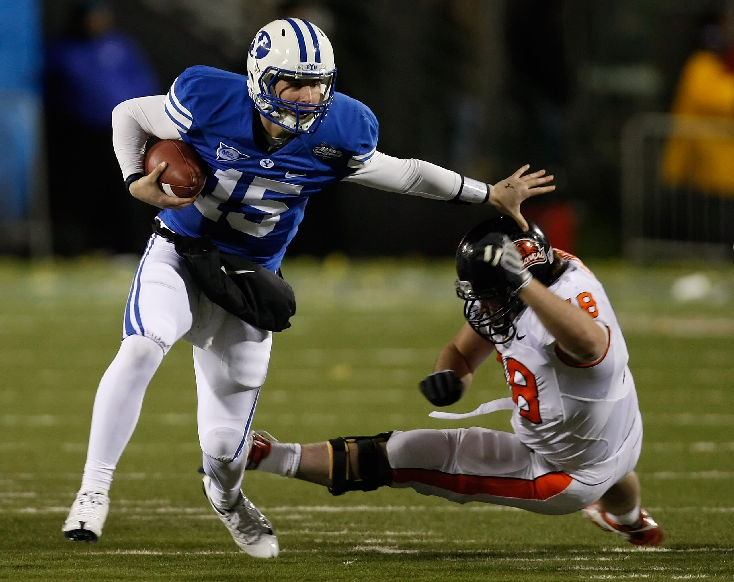 LAS VEGAS - DECEMBER 22:  Quarterback Max Hall #15 of the Brigham Young University Cougars runs for yardage against Ben Motter #78 of the Oregon State Beavers during the MAACO Las Vegas Bowl at Sam Boyd Stadium December 22, 2009 in Las Vegas, Nevada.  (Ph