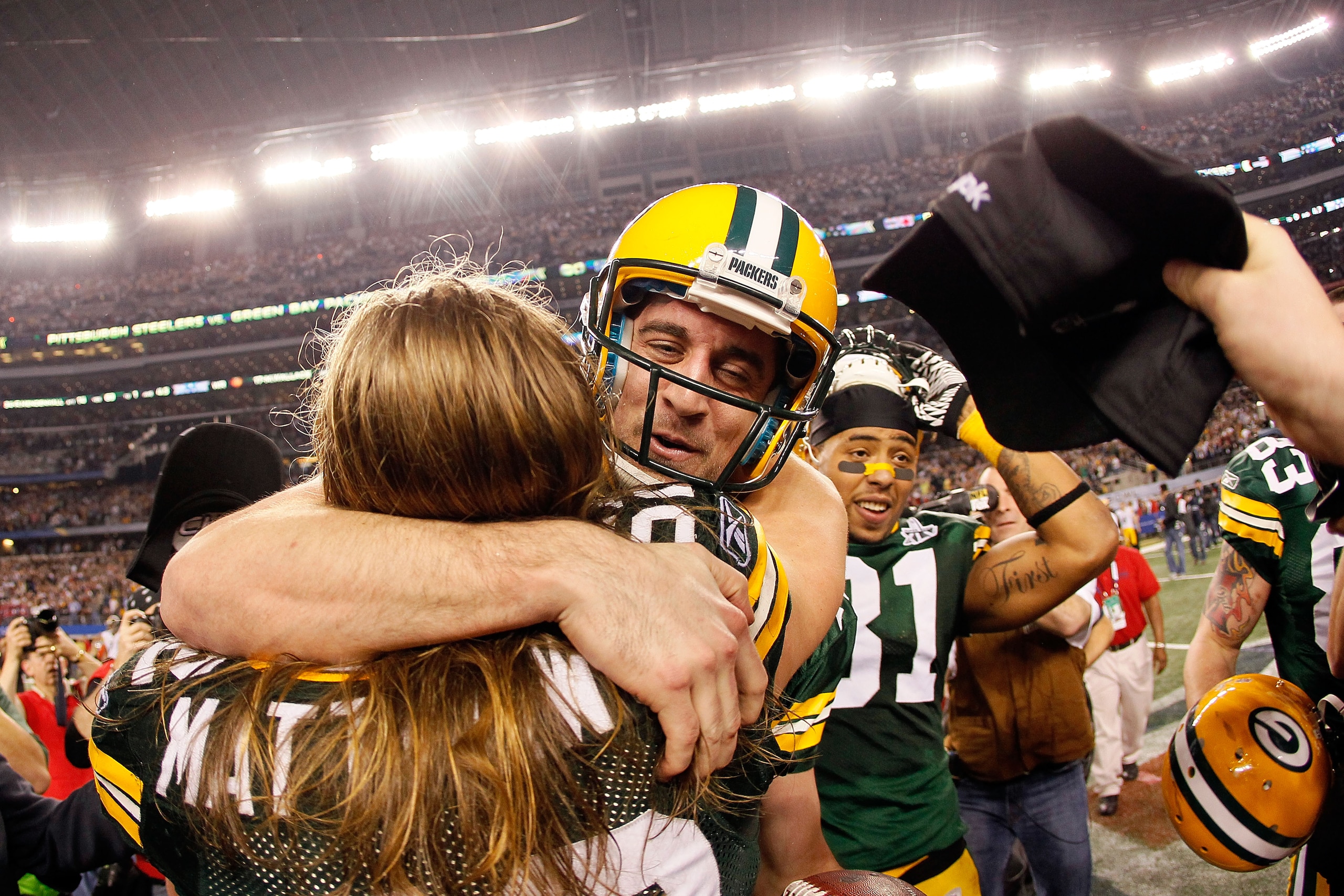 ARLINGTON, TX - FEBRUARY 06: Super Bowl MVP Aaron Rodgers #12 hugs Clay Matthews #52 of the Green Bay Packers as Andrew Quarless #81 looks on after winning Super Bowl XLV 31-25 against the Pittsburgh Steelers at Cowboys Stadium on February 6, 2011 in Arli