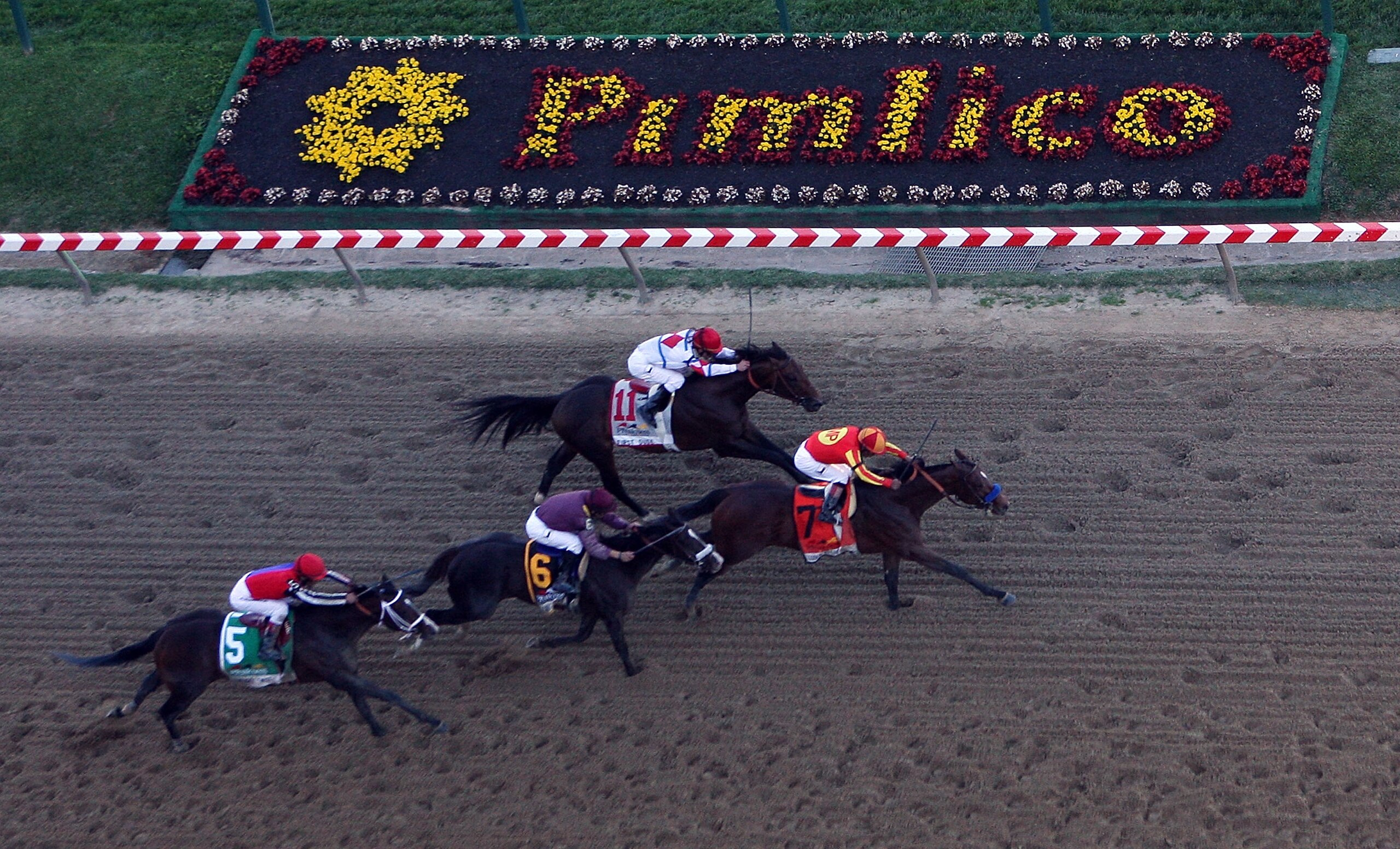 BALTIMORE - MAY 15:  Lookin At Lucky (center), ridden by Martin Garcia #7, holds off First Dude, ridden by Ramon Dominguez #11, Jackson Bend , ridden by Mike Smith #6, and Yawanna Twist, ridden by Edgar Prado #5, down the homestrech to win the 135th runni