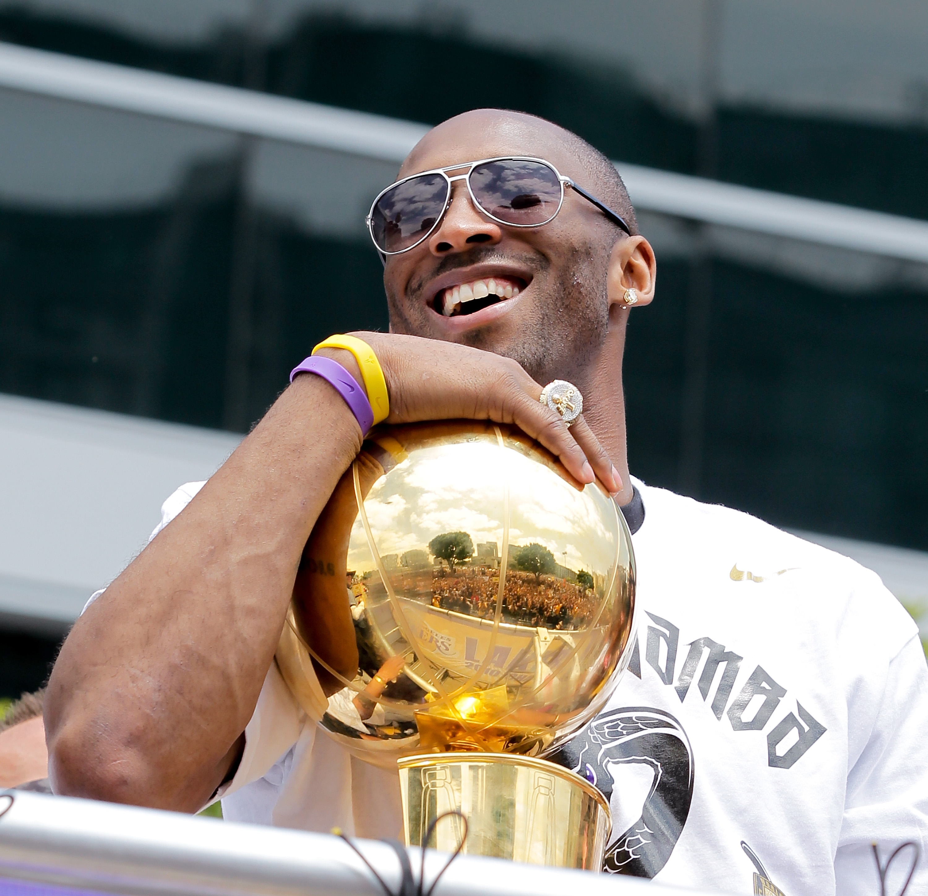 LOS ANGELES, CA - JUNE 21:  Los Angeles Lakers guard Kobe Bryant laughs with the championship trophy while riding in the victory parade for the the NBA basketball champion team on June 21, 2010 in Los Angeles, California. The Lakers beat the Boston Celtic