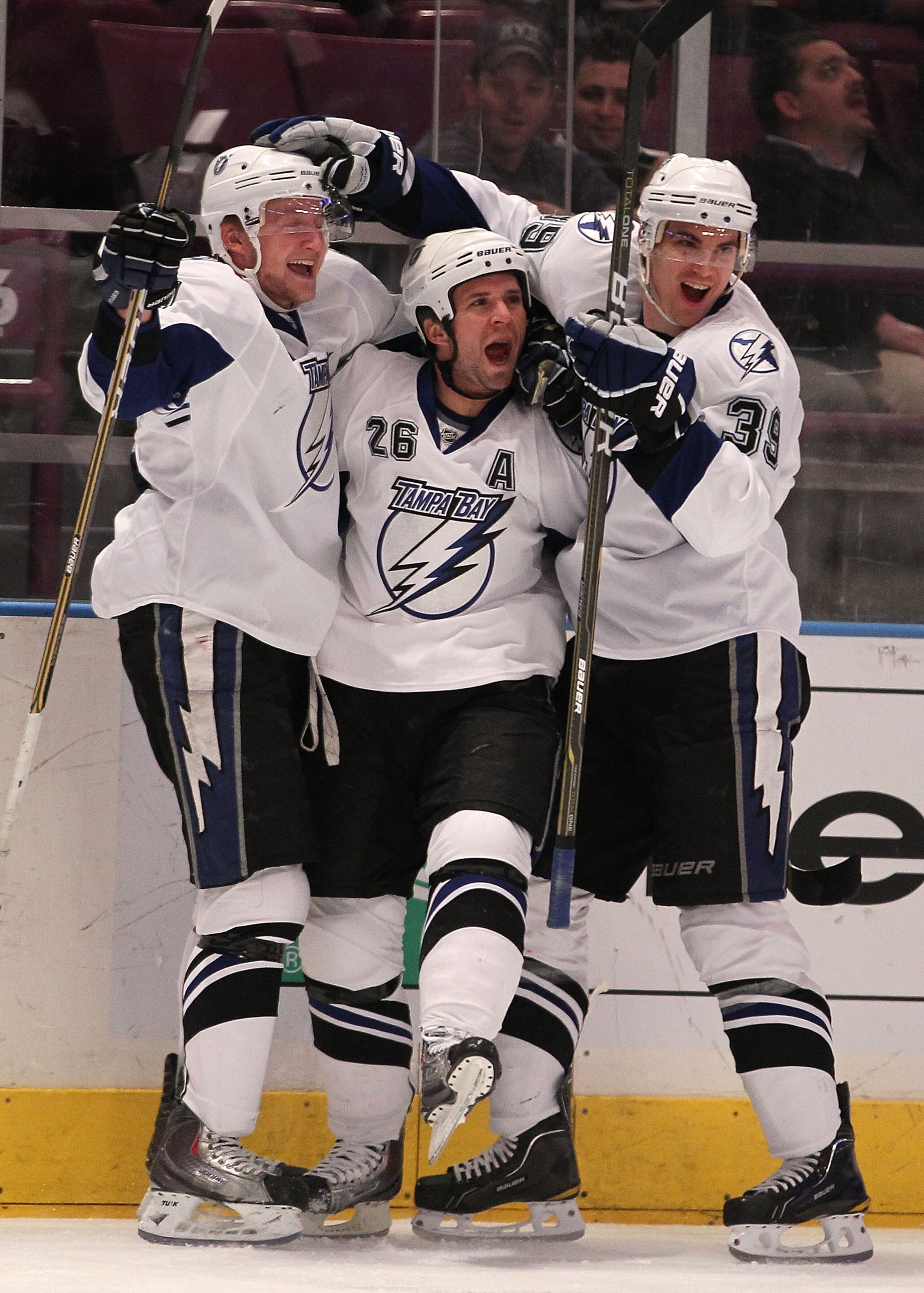 NEW YORK, NY - DECEMBER 23:  Steven Stamkos #91, Martin St. Louis #26 and Mike Lundin #39 of the Tampa Bay Lightning celebrate a goal by St. Louis during the first period of an NHL hockey game at Madison Square Garden on December 23, 2010 in New York City