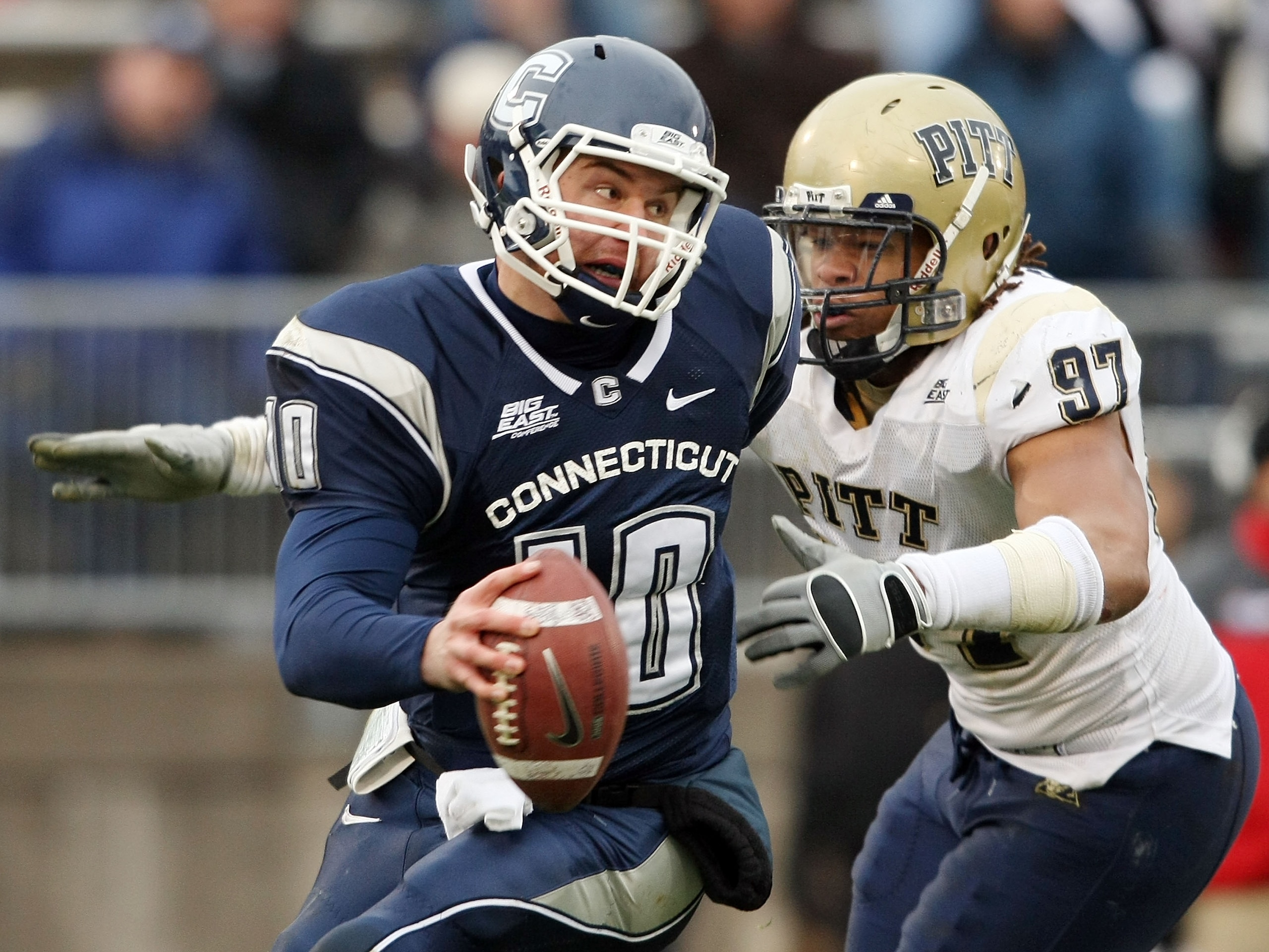 EAST HARTFORD, CT - DECEMBER 06:  Zach Frazer #10 of the Connecticut Huskies narrowly escapes Jabaal Sheard #97 of the Pittsburgh Panthers on December 6, 2008 at Rentschler Field in East Hartford, Connecticut. The Panthers defeated the Huskies 34-10.  (Ph