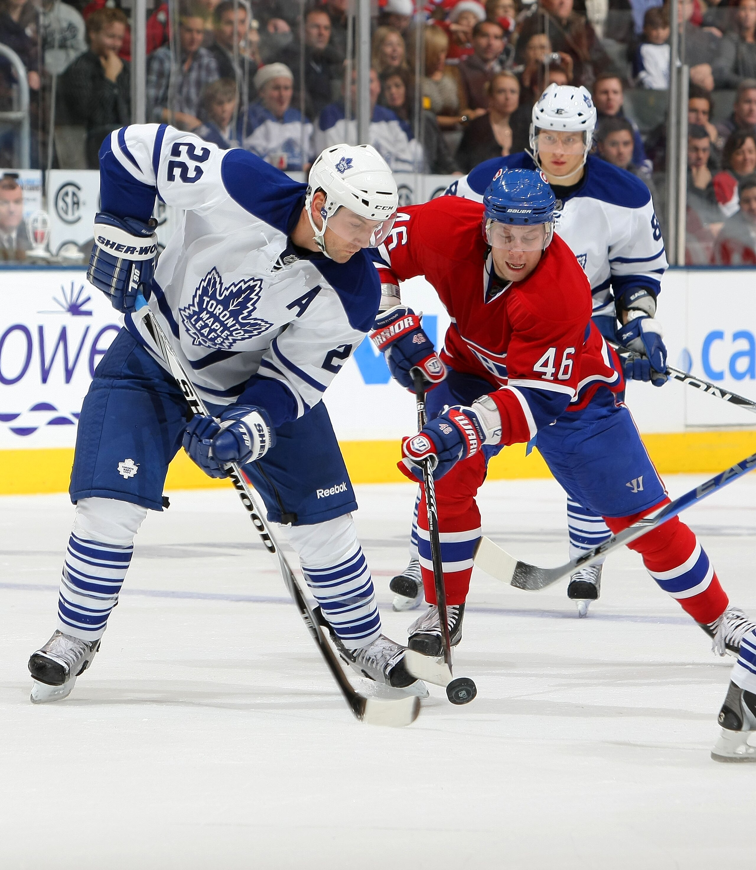 TORONTO - DECEMBER 11:  Francois Beauchemin #22 of the Toronto Maple Leafs battles for the puck with Andrei Kostitsyn #46 of the Montreal Canadiens during their NHL game at Air Canada Centre on December 11, 2010 in Toronto, Ontario, Canada.(Photo By Dave
