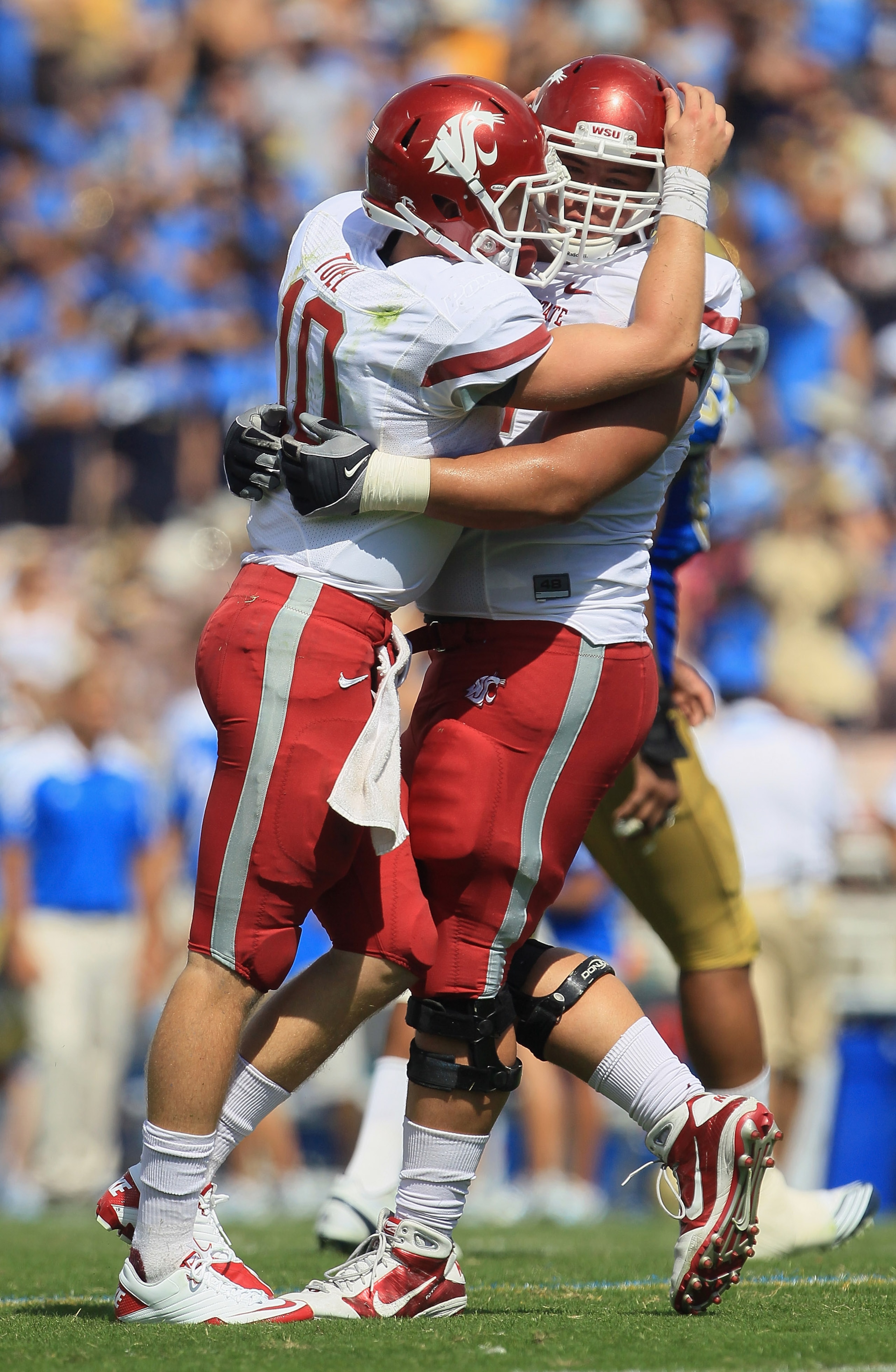 PASADENA, CA - OCTOBER 02:  Quarterback Jeff Tuel (L) #10 of the Washington State Cougars celebrates a touchdown with teammate B.J. Guerra #72 during the second quarter against the UCLA Bruins at the Rose Bowl on October 2, 2010 in Pasadena, California.