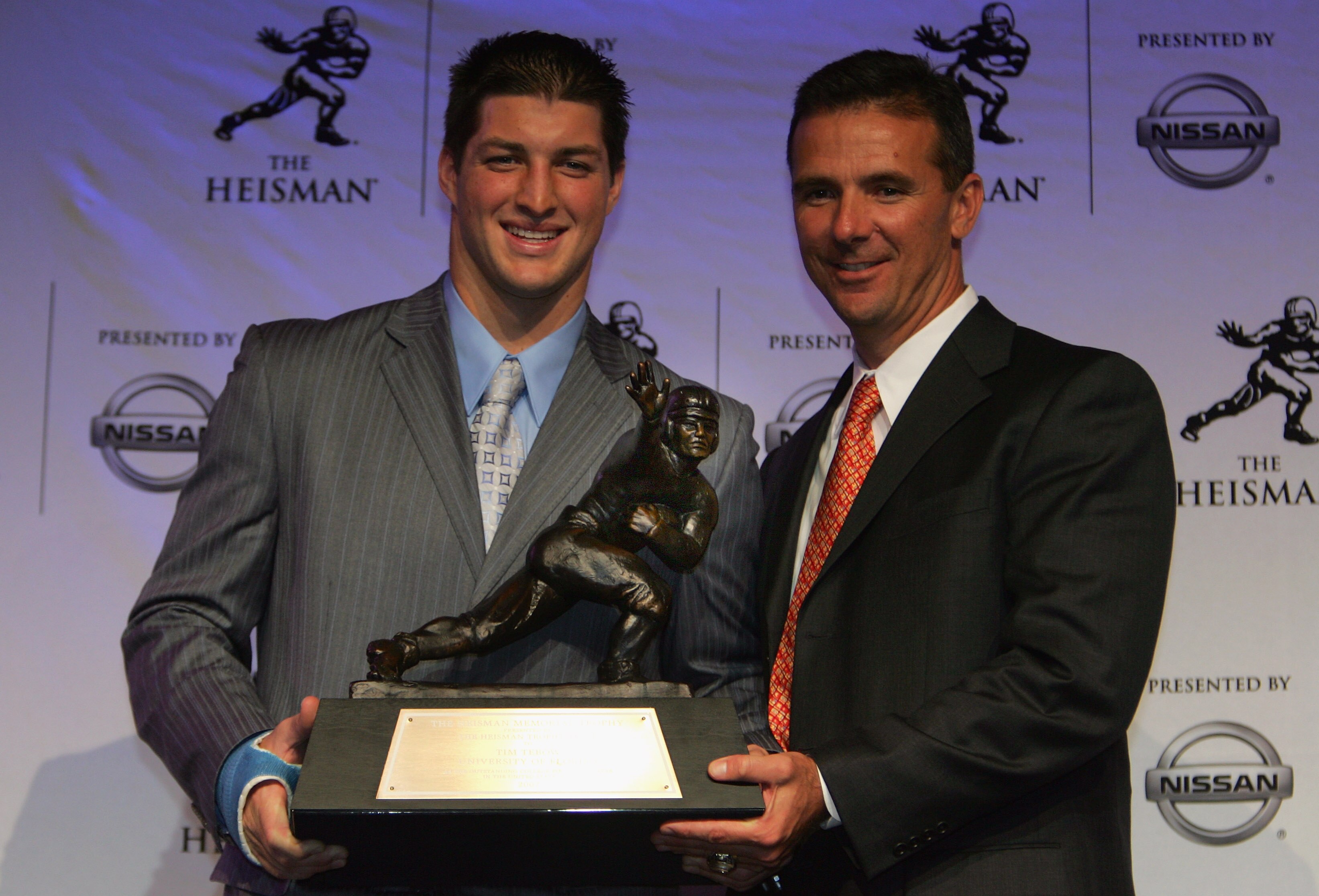 NEW YORK - DECEMBER 08:  Quarterback Tim Tebow (L) of the University of Florida and head coach Urban Meyer pose with the Heisman trophy after winning the 73rd Annual Heisman Memorial Trophy Award on December 8, 2007 in New York City.  (Photo by Chris Trot