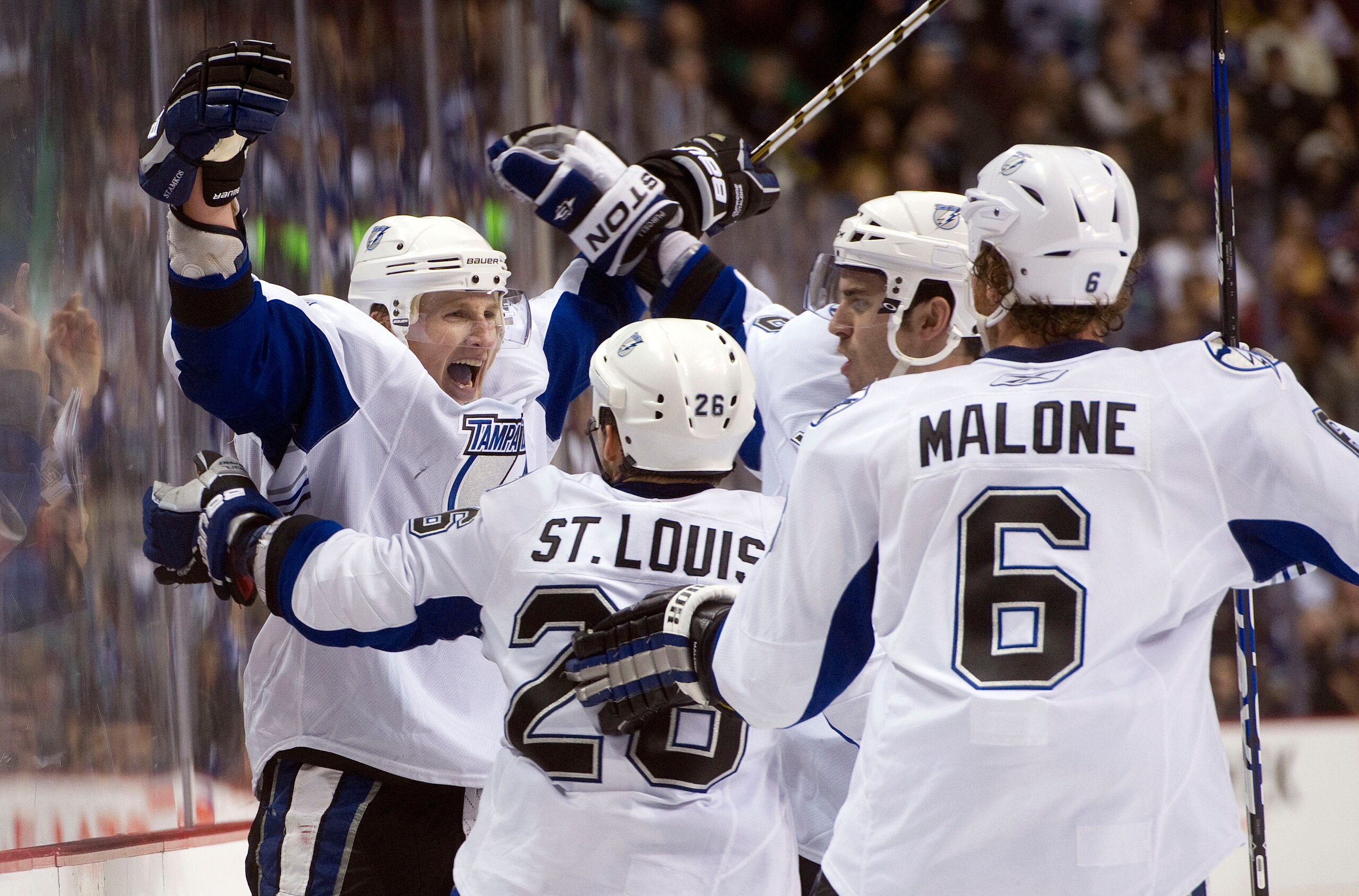 VANCOUVER, CANADA - DECEMBER 11: Steven Stamkos #91 of the Tampa Bay Lightning celebrates with Martin St Louis #26, Ryan Malone #6 and Teddy Purcell #16 after scoring against the Vancouver Canucks in overtime to win 5-4 during NHL action on December 11, 2