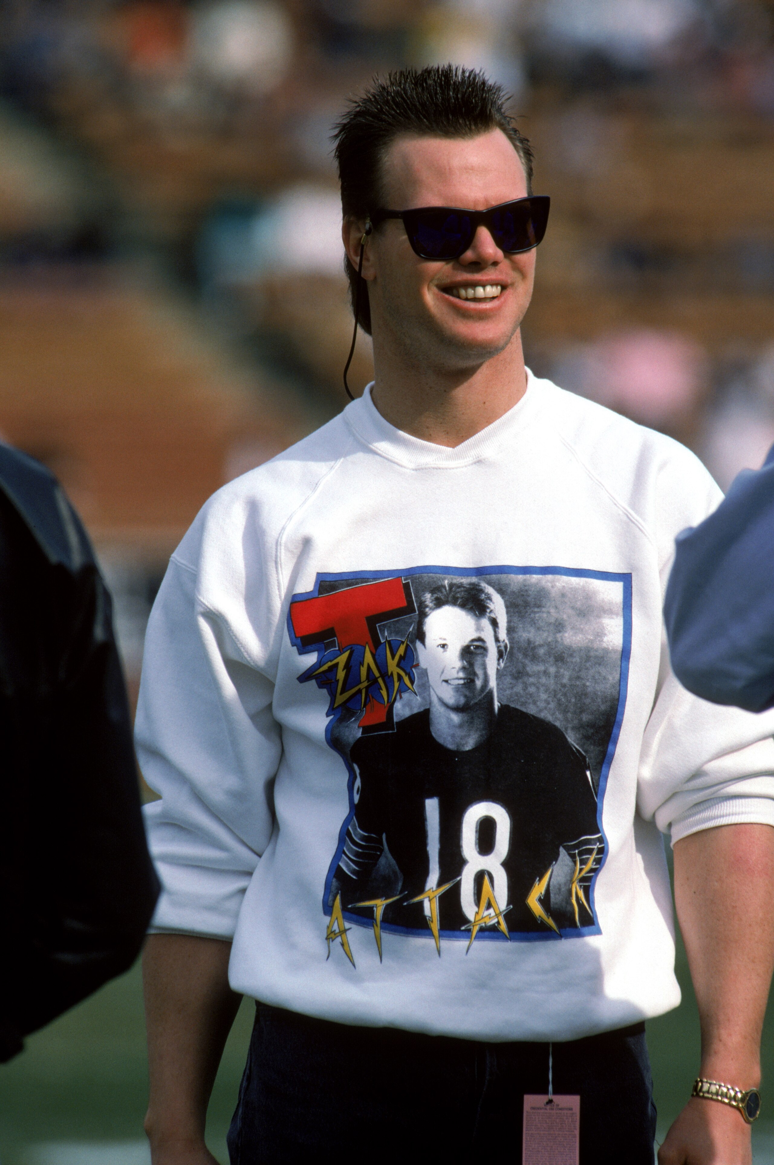 LOS ANGELES - DECEMBER 27: Injured quarterback Jim McMahon of the Chicago Bears shows his support for teammate quarterback Mike Tomczak as he wears a Mike Tomczak T-shirt during a game against the Los Angeles Raiders at the Los Angeles Memorial Coliseum LOS ANGELES - DECEMBER 27: Injured quarterback Jim McMahon of the Chicago Bears shows his support for teammate quarterback Mike Tomczak as he wears a Mike Tomczak T-shirt during a game against the Los Angeles Raiders at the Los Angeles Memorial Coliseum