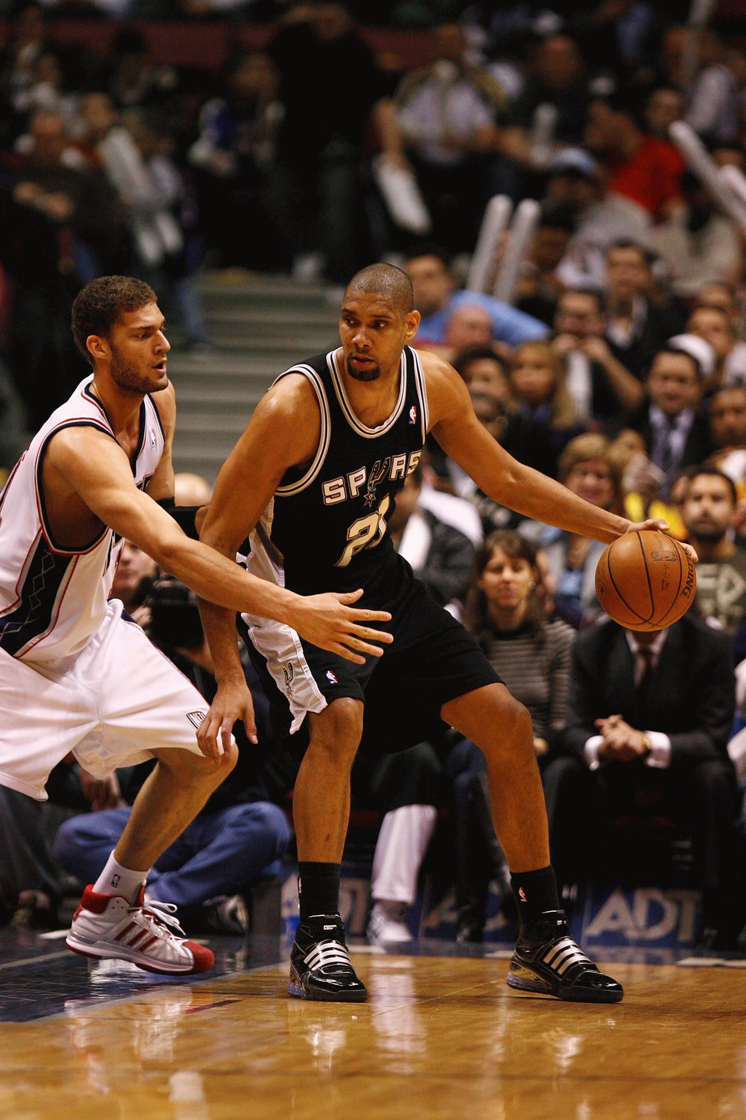 EAST RUTHERFORD, NJ - FEBRUARY 10:  Tim Duncan #21 of the San Antonio Spurs dribbles against Brook Lopez #11 of The New Jersey Nets during their game on February 10, 2009 at The Izod Center in East Rutherford, New Jersey.  NOTE TO USER: User expressly ack