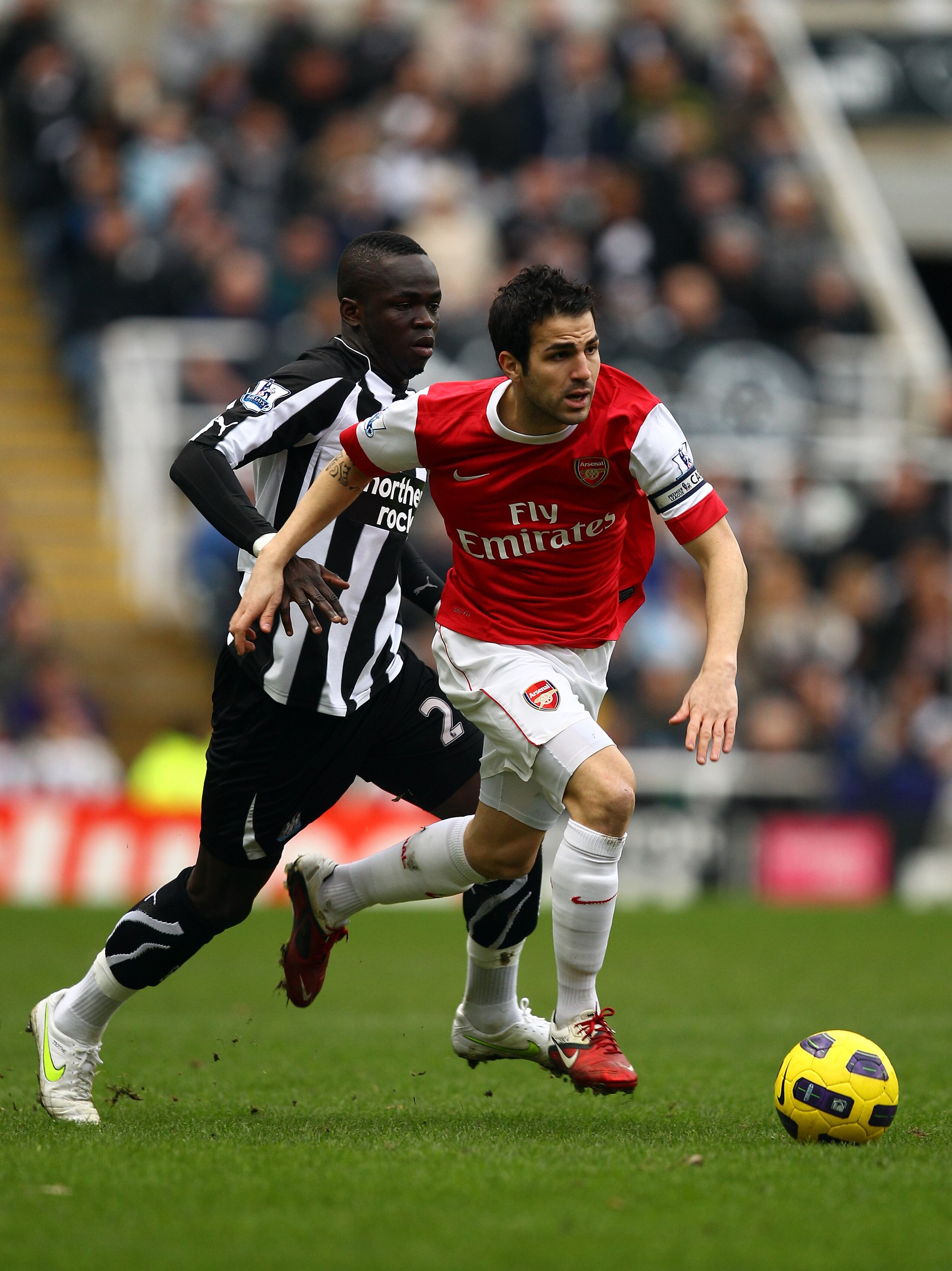 NEWCASTLE UPON TYNE, ENGLAND - FEBRUARY 05:  Cesc Fabregas of Arsenal breaks away from Cheik Tiote of Newcastle during the Barclays Premier League match between Newcastle United and Arsenal at St James' Park on February 5, 2011 in Newcastle upon Tyne, Eng