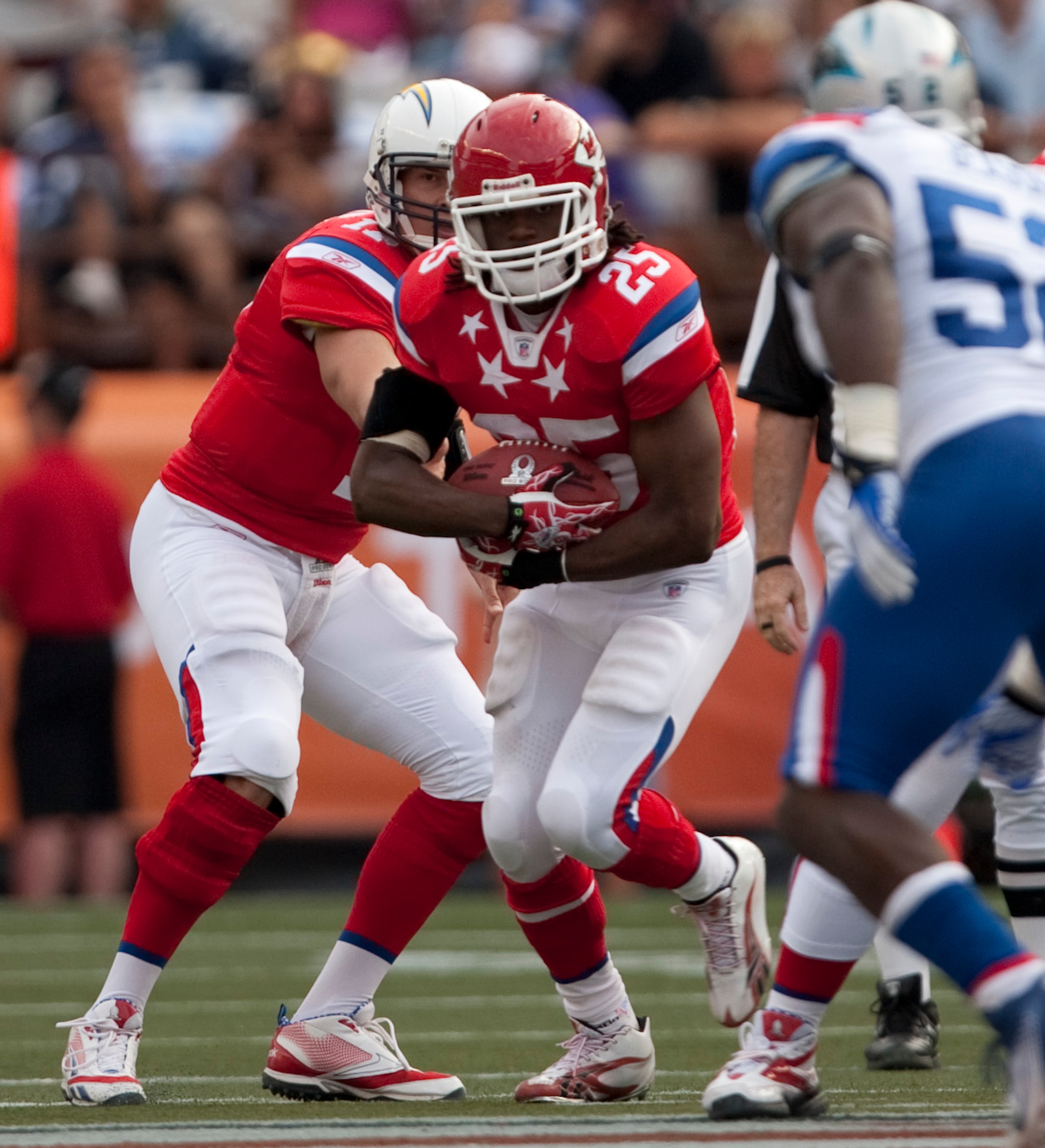 HONOLULU - JANUARY 30:  Jamaal Charles, #25 of the Kansas City Chiefs, is handed the ball by Philip Rivers, #17 of the San Diego Chargers, during the 2011 NFL Pro Bowl at Aloha Stadium on January 30, 2011 in Honolulu, Hawaii.  (Photo by Kent Nishimura/Get