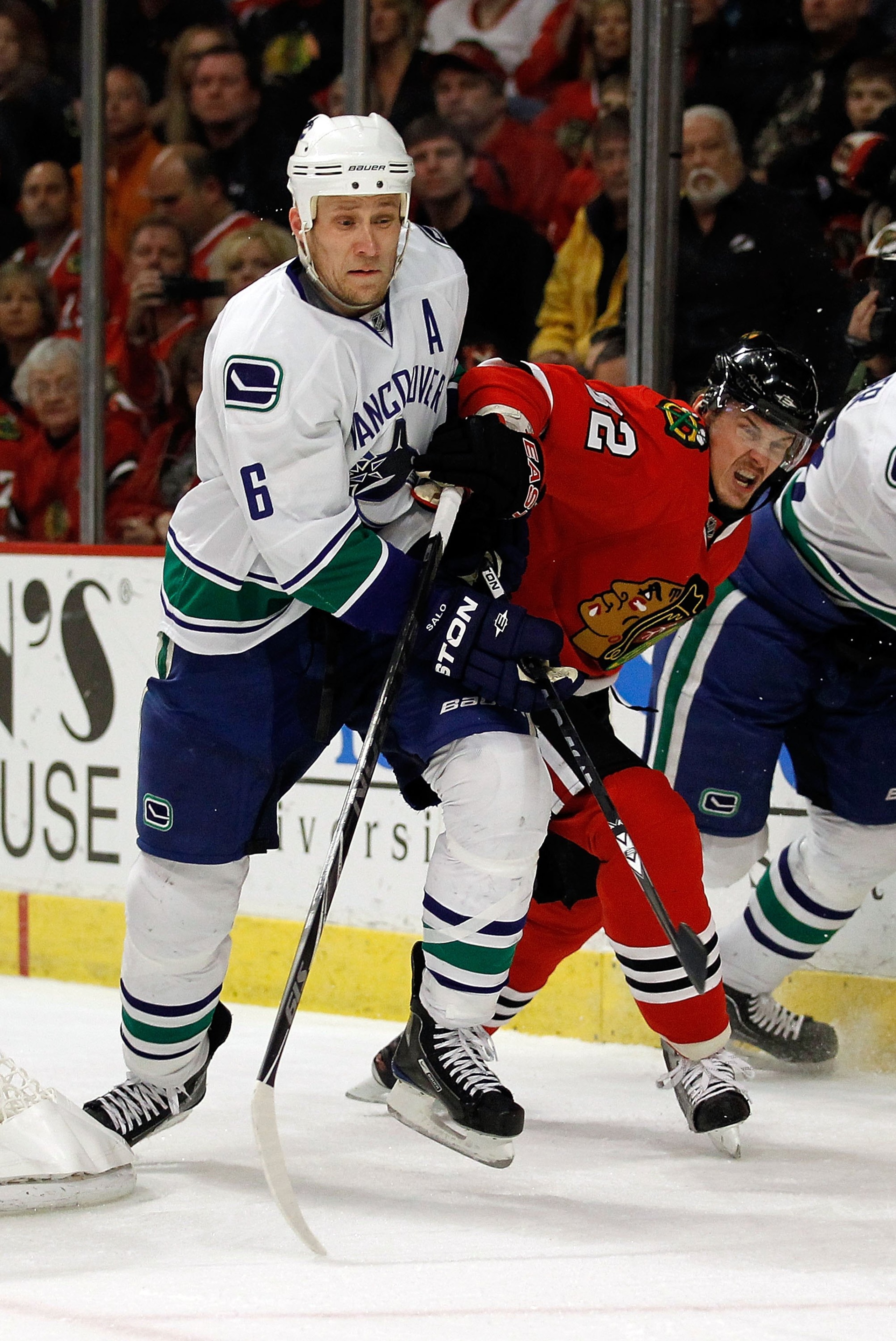CHICAGO - MAY 09: Tomas Kopecky #82 of the Chicago Blackhawks and Sami Salo #6 of the Vancouver Canucks battle behind the net in Game Five of the Western Conference Semifinals during the 2010 NHL Stanley Cup Playoffs at United Center on May 9, 2010 in Chi