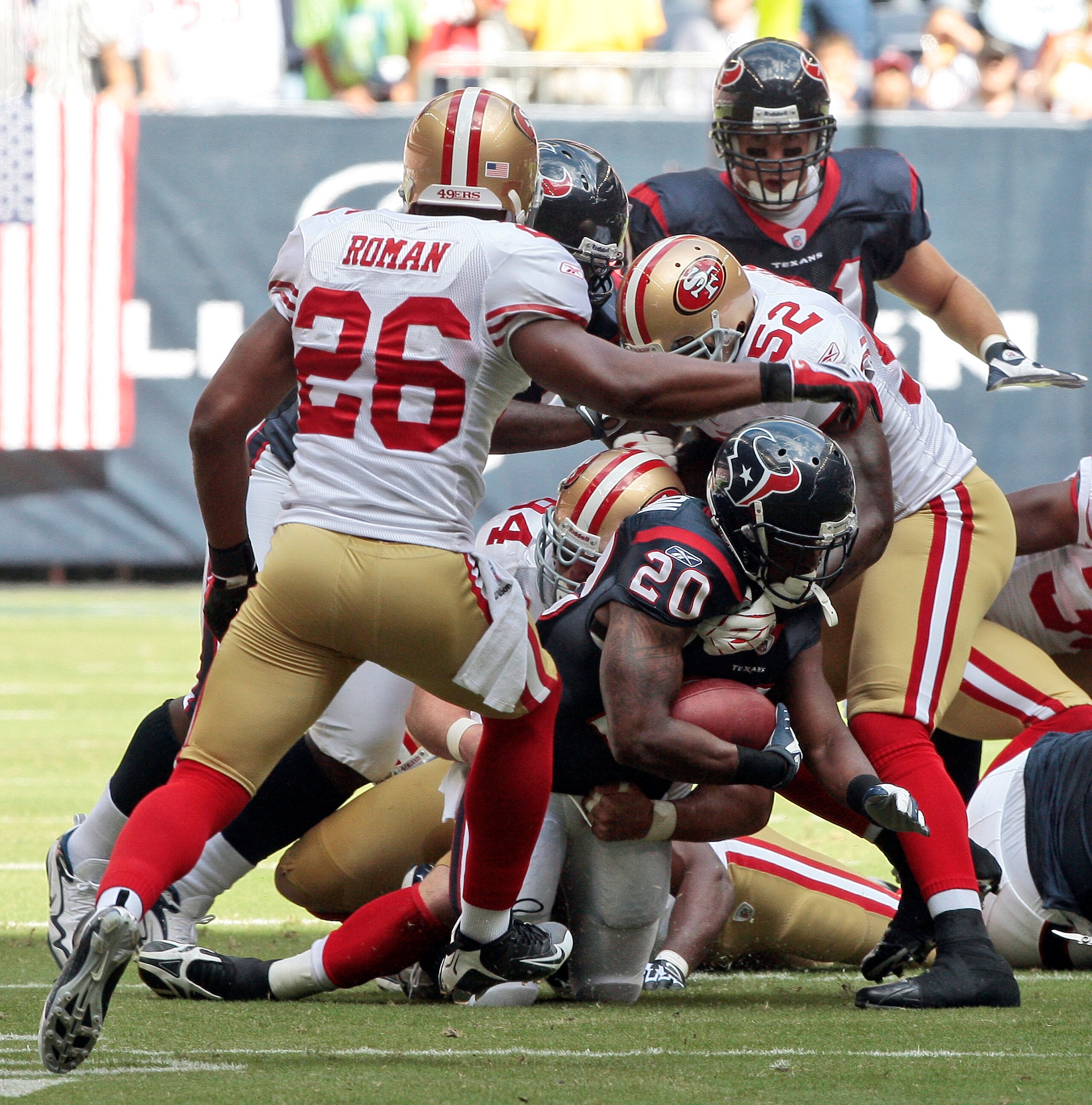 HOUSTON - OCTOBER 25:  Running back Steve Slaton #20 of the Houston Texans is tackled by linebacker Patrick Willis #52 and Mark Roman #26 of the San Francisco 49ers at Reliant Stadium on October 25, 2009 in Houston, Texas.  (Photo by Bob Levey/Getty Image