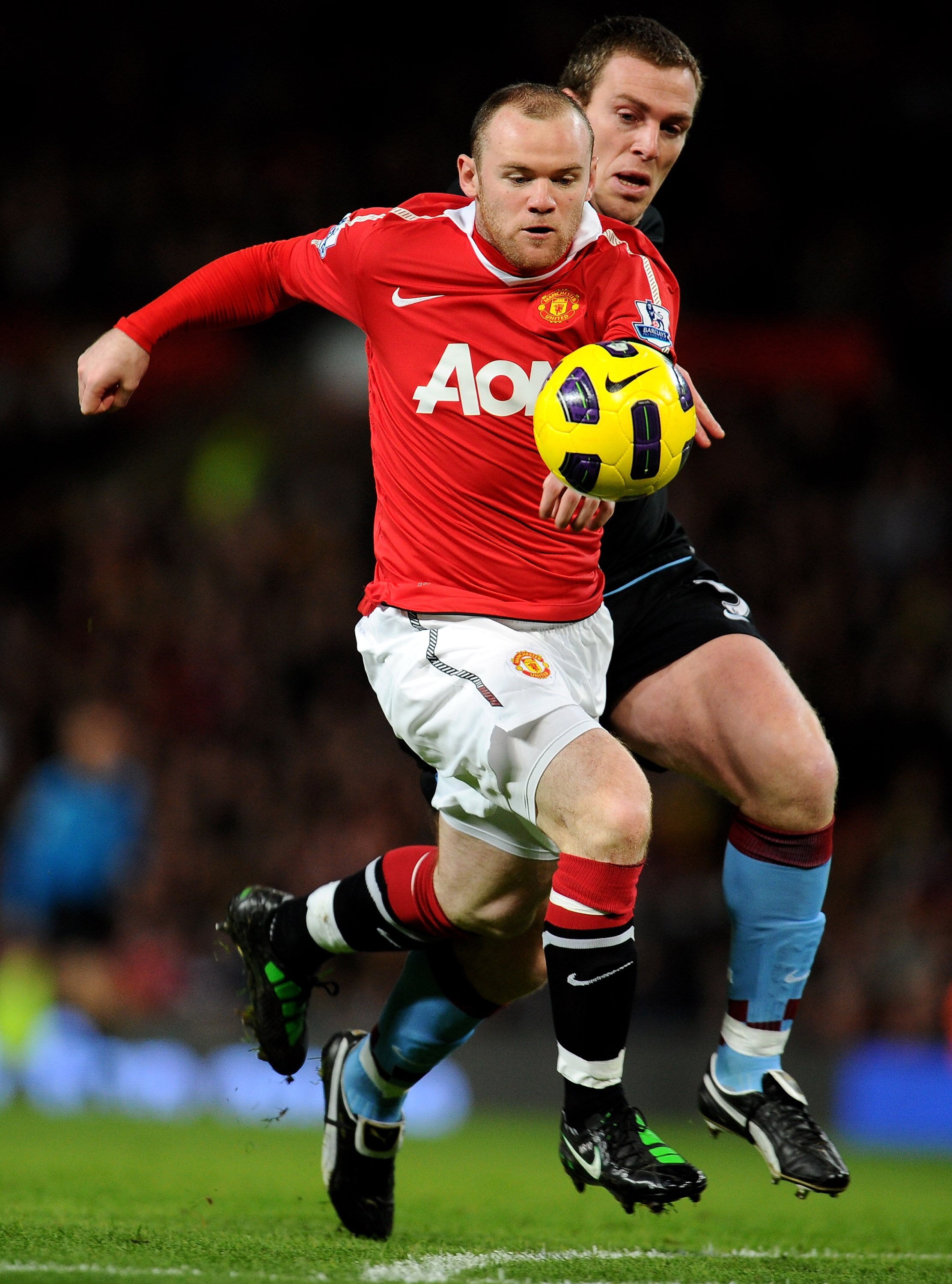 MANCHESTER, ENGLAND - FEBRUARY 01:  Wayne Rooney of Manchester United beats Richard Dunne of Aston Villa to the ball prior to scoring the opening goal during the Barclays Premier League match between Manchester United and Aston Villa at Old Trafford on Fe