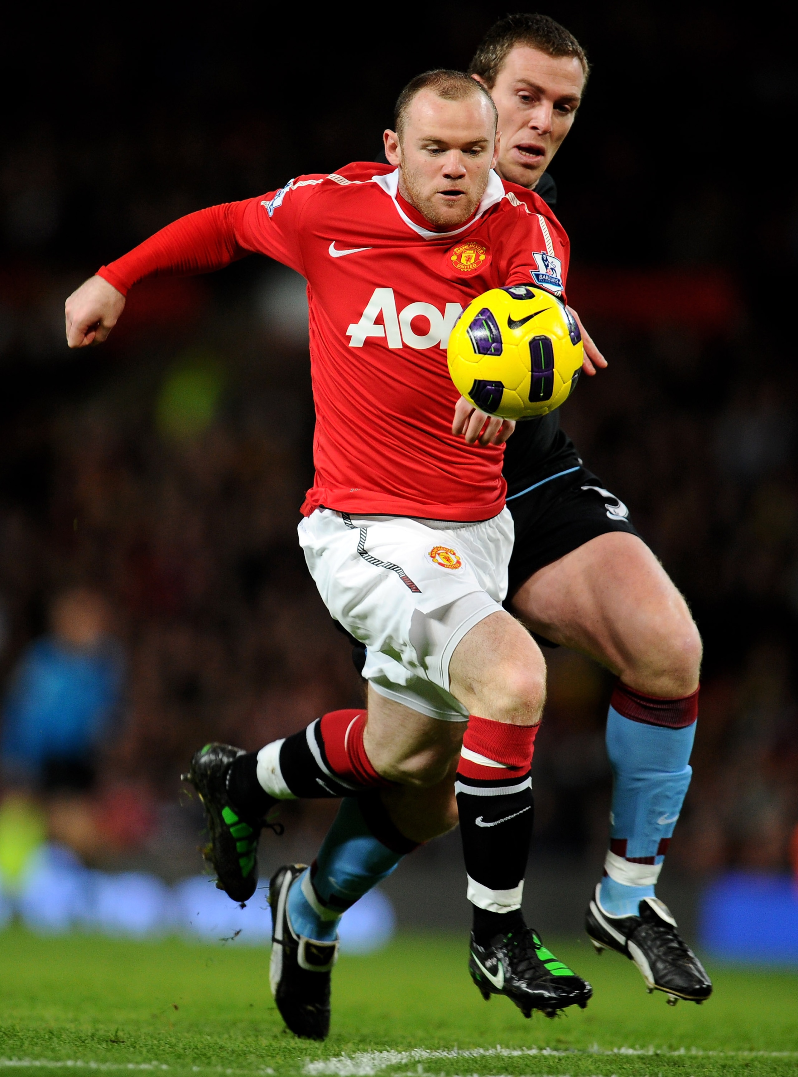 MANCHESTER, ENGLAND - FEBRUARY 01:  Wayne Rooney of Manchester United beats Richard Dunne of Aston Villa to the ball prior to scoring the opening goal during the Barclays Premier League match between Manchester United and Aston Villa at Old Trafford on Fe