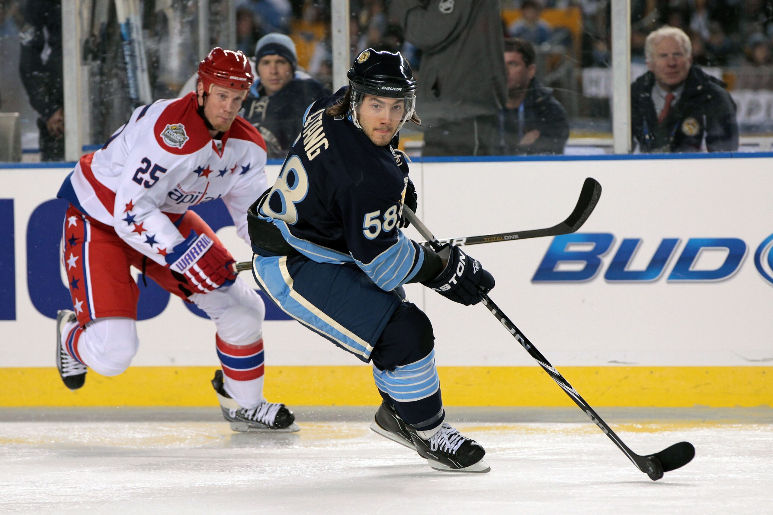 PITTSBURGH, PA - JANUARY 01:  Kris Letang #58 of the Pittsburgh Penguins moves the puck against Jason Chimera #25 of the Washington Capitals during the 2011 NHL Bridgestone Winter Classic at Heinz Field on January 1, 2011 in Pittsburgh, Pennsylvania. Wash