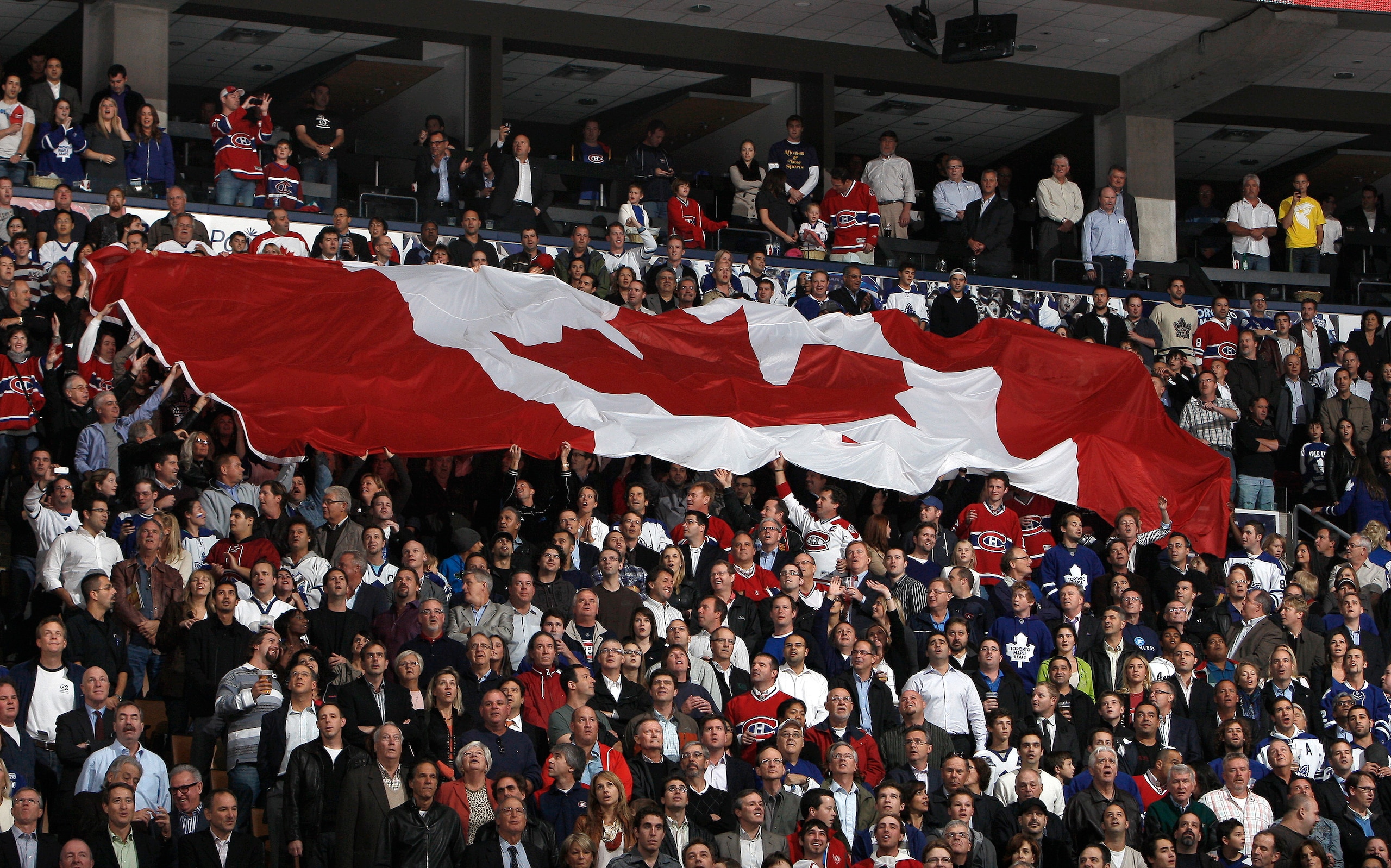 TORONTO, CANADA - OCTOBER 07: A giant Canadian flag is passed around during an opening night pre-game ceremony before a regular season NHL game between the Toronto Maple Leafs  and the Montreal Canadiens at the Air Canada Centre October 7, 2010 in Toronto