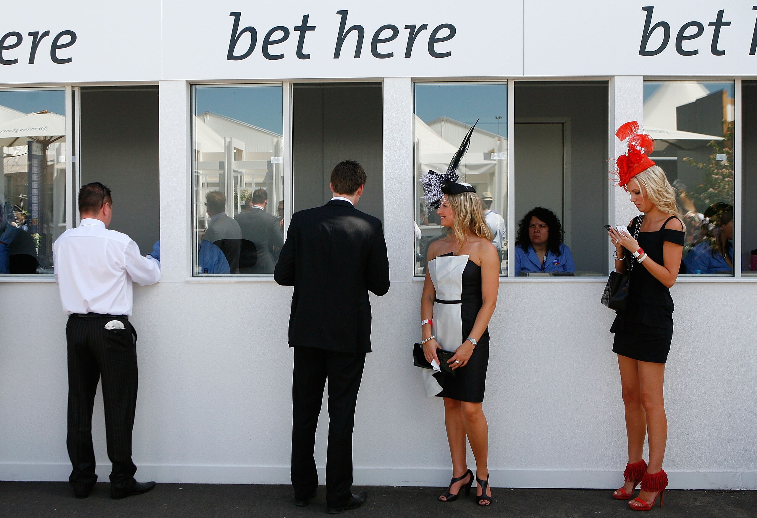 MELBOURNE, AUSTRALIA - OCTOBER 31:  Racegoers place a bet during the AAMI Victoria Derby Day at Flemington Racecourse on October 31, 2009 in Melbourne, Australia.  (Photo by Scott Barbour/Getty Images)