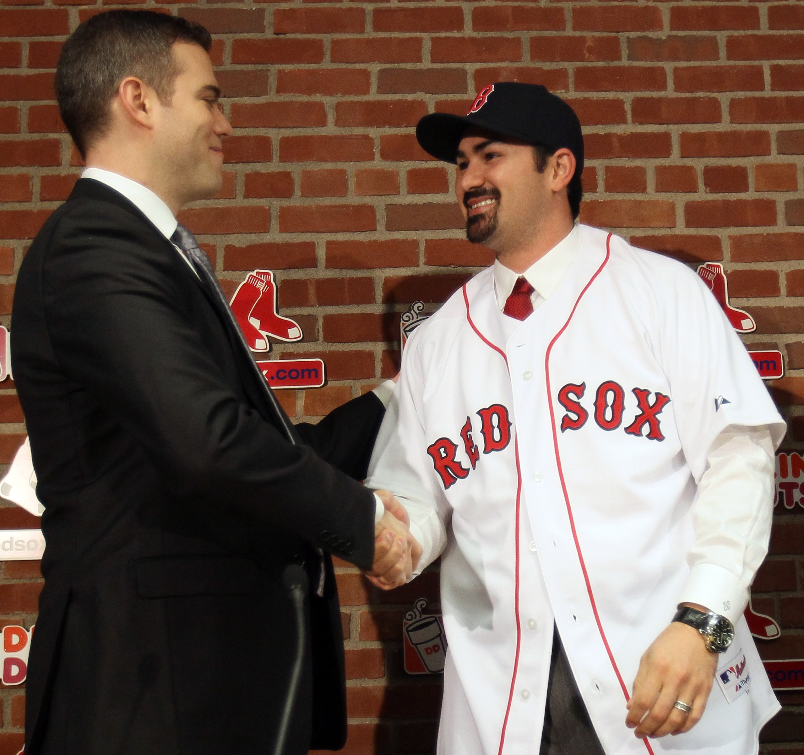 BOSTON, MA - DECEMBER 06:  Adrian Gonzalez (R) shakes hands with Boston Red Sox General Manager Theo Epstein after it was announced that Gonzalez signed with the Boston Red Sox on December 6,  2010 at Fenway Park in Boston, Massachusetts.  (Photo by Elsa/
