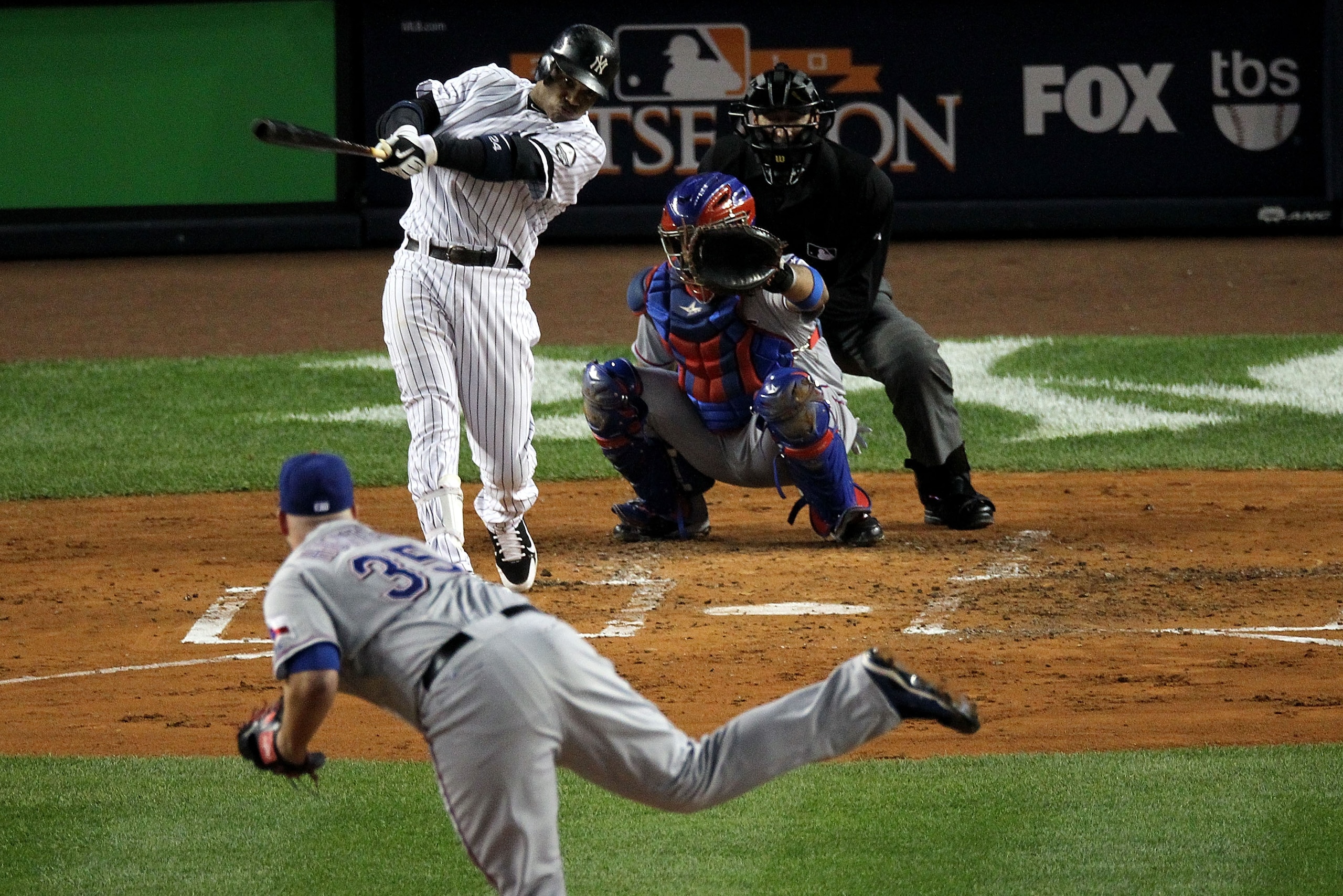 NEW YORK - OCTOBER 19:  Robinson Cano #24 of the New York Yankees hits a solo homr run in the bottom of the second inning against the Texas Rangers in Game Four of the ALCS during the 2010 MLB Playoffs at Yankee Stadium on October 19, 2010 in the Bronx bo