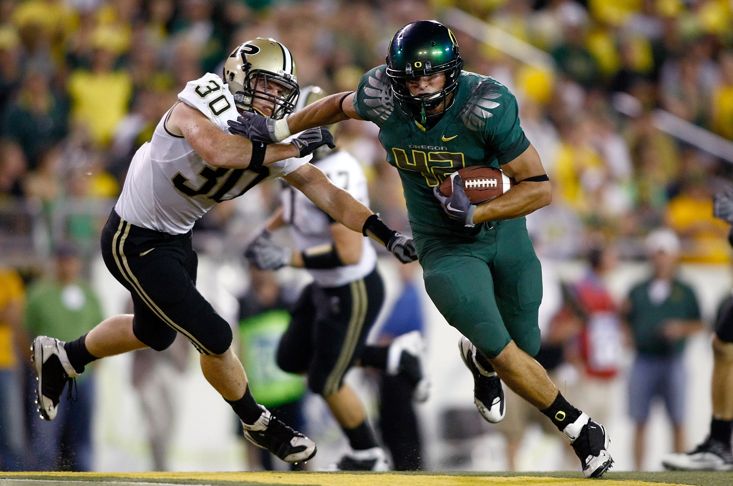 EUGENE, OR - SEPTEMBER 12:  David Paulson #42 of the Oregon Ducks runs with the ball against Joe Holland #30 of the Purdue Boilermakers  at Autzen Stadium on September 12, 2009 in Eugene, Oregon.  (Photo by Jonathan Ferrey/Getty Images)