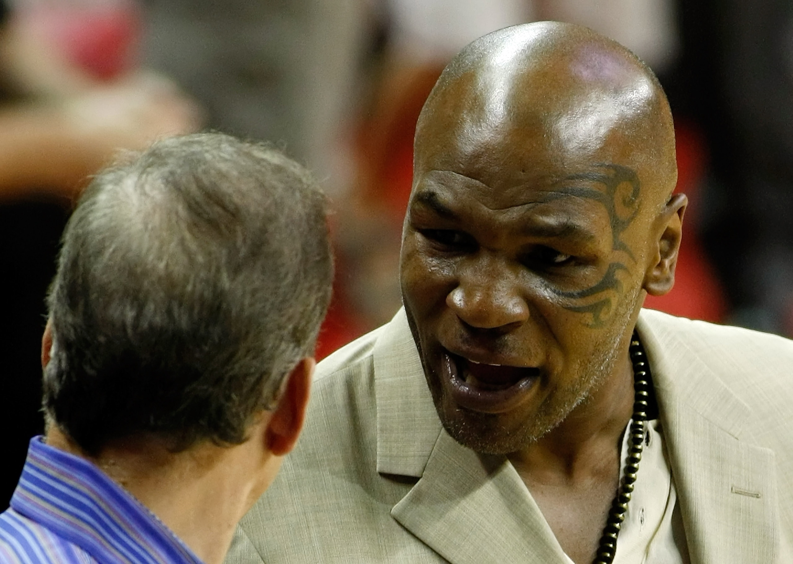 LAS VEGAS - OCTOBER 13:  Sportscaster Jim Gray (L) and former boxer Mike Tyson talk during a preseason game between the Los Angeles Lakers and the Sacramento Kings at the Thomas & Mack Center October 13, 2010 in Las Vegas, Nevada. The Lakers won 98-95. NO