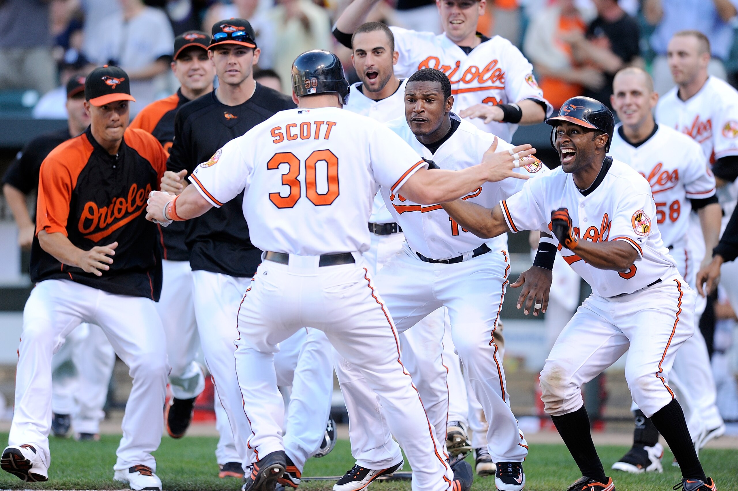 BALTIMORE - SEPTEMBER 19: Luke Scott #30 of the Baltimore Orioles is congratulated by Adam Jones #10, Corey Patterson #6, Nick Markakis #21 and other teammates after scoring the game winning run in the eleventh inning against the New York Yankees at Camd BALTIMORE - SEPTEMBER 19: Luke Scott #30 of the Baltimore Orioles is congratulated by Adam Jones #10, Corey Patterson #6, Nick Markakis #21 and other teammates after scoring the game winning run in the eleventh inning against the New York Yankees at Camd
