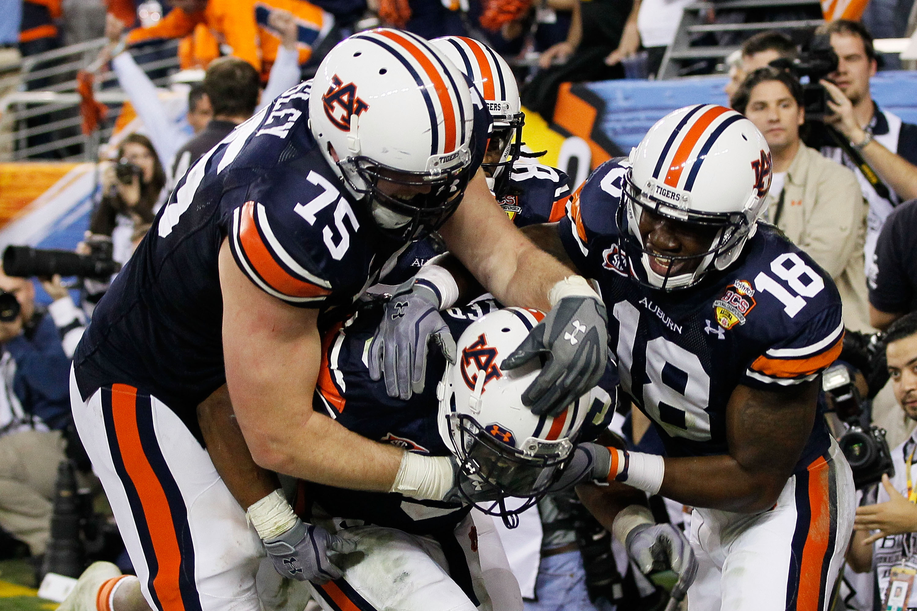 GLENDALE, AZ - JANUARY 10: (C) Michael Dyer #5 of the Auburn Tigers celebrates with teammates Brandon Mosley #75 and Kodi Burns #18 after he ran the ball for 16-yards and is called down at the one-yardline with 10 seconds remaining in the fourth quarter