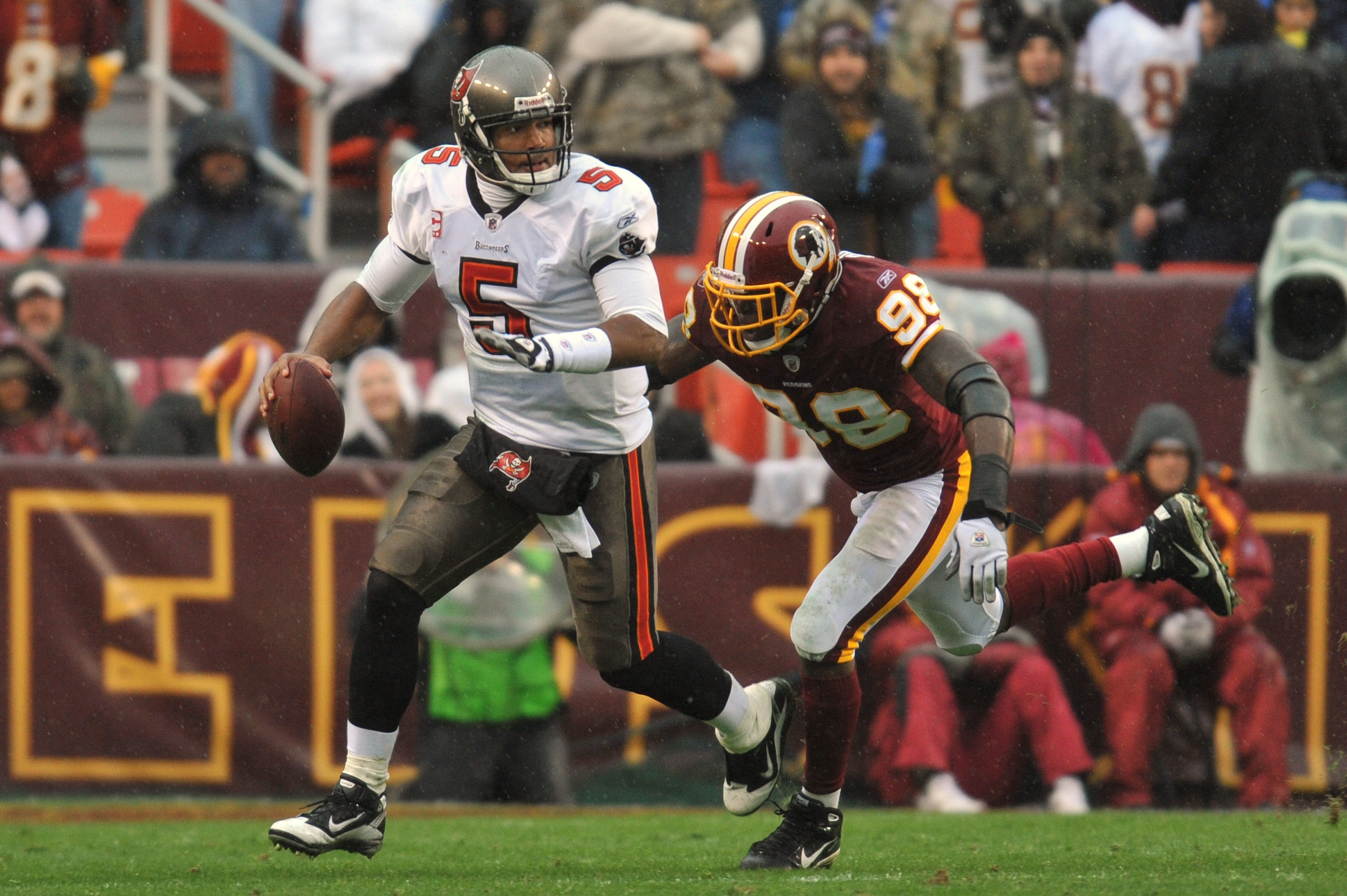 LANDOVER, MD - DECEMBER 12:  Josh Freeman #5 of the Tampa Bay Buccaneers is chased by Brian Orakpo #98 of the Washington Redskins at FedExField on December 12, 2010 in Landover, Maryland. The Redskins led the Buccaneers at the half 10-3 00-00. (Photo by L
